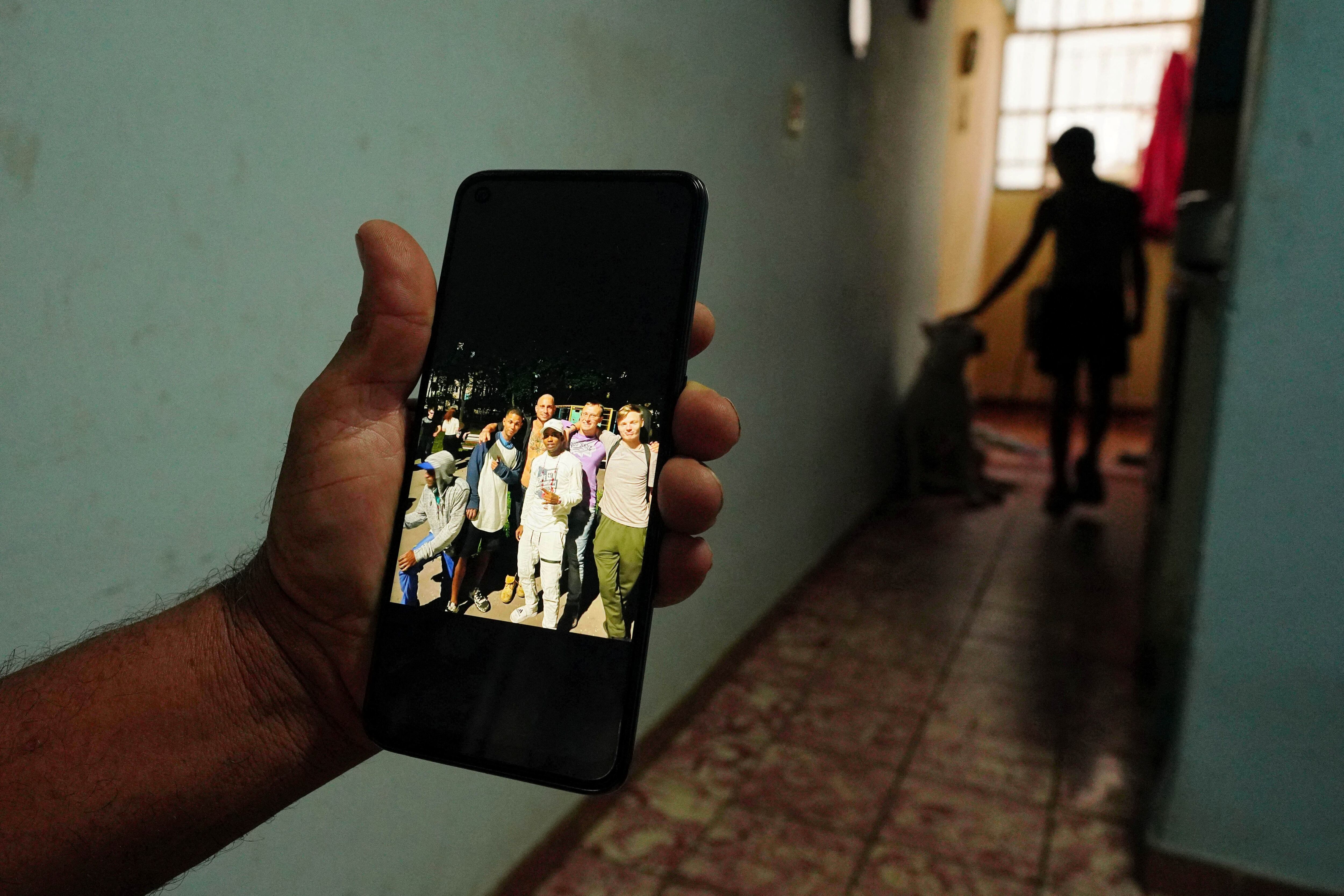 Un pariente muestra la foto de Dannys Castillo (C), quien se encuentra en Rusia junto a otros cubanos (REUTERS/Alexandre Meneghini)