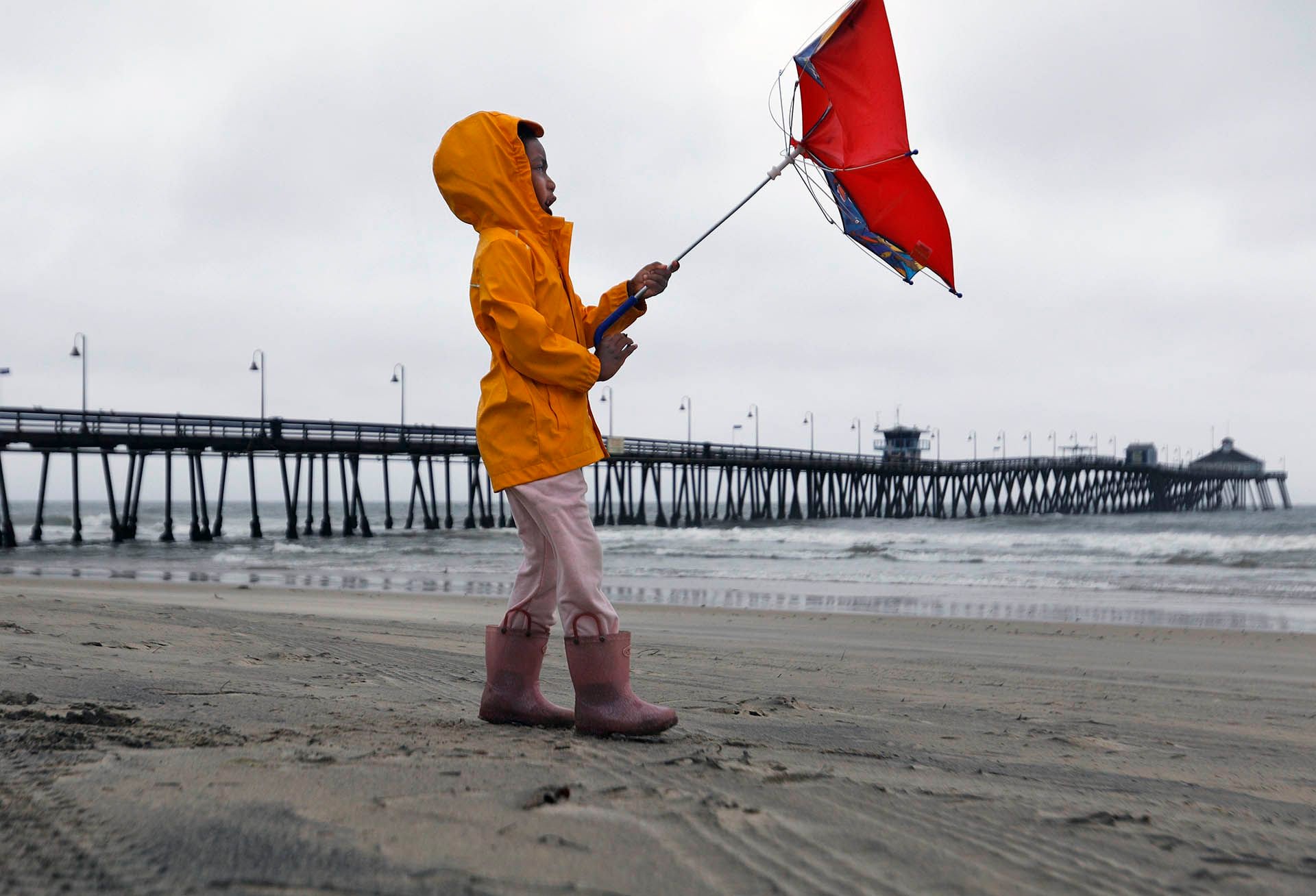 Reagan King lucha contra el viento mientras estaba con sus padres en Imperial Beach después de que pasara el ojo de la tormenta tropical Hilary el domingo.