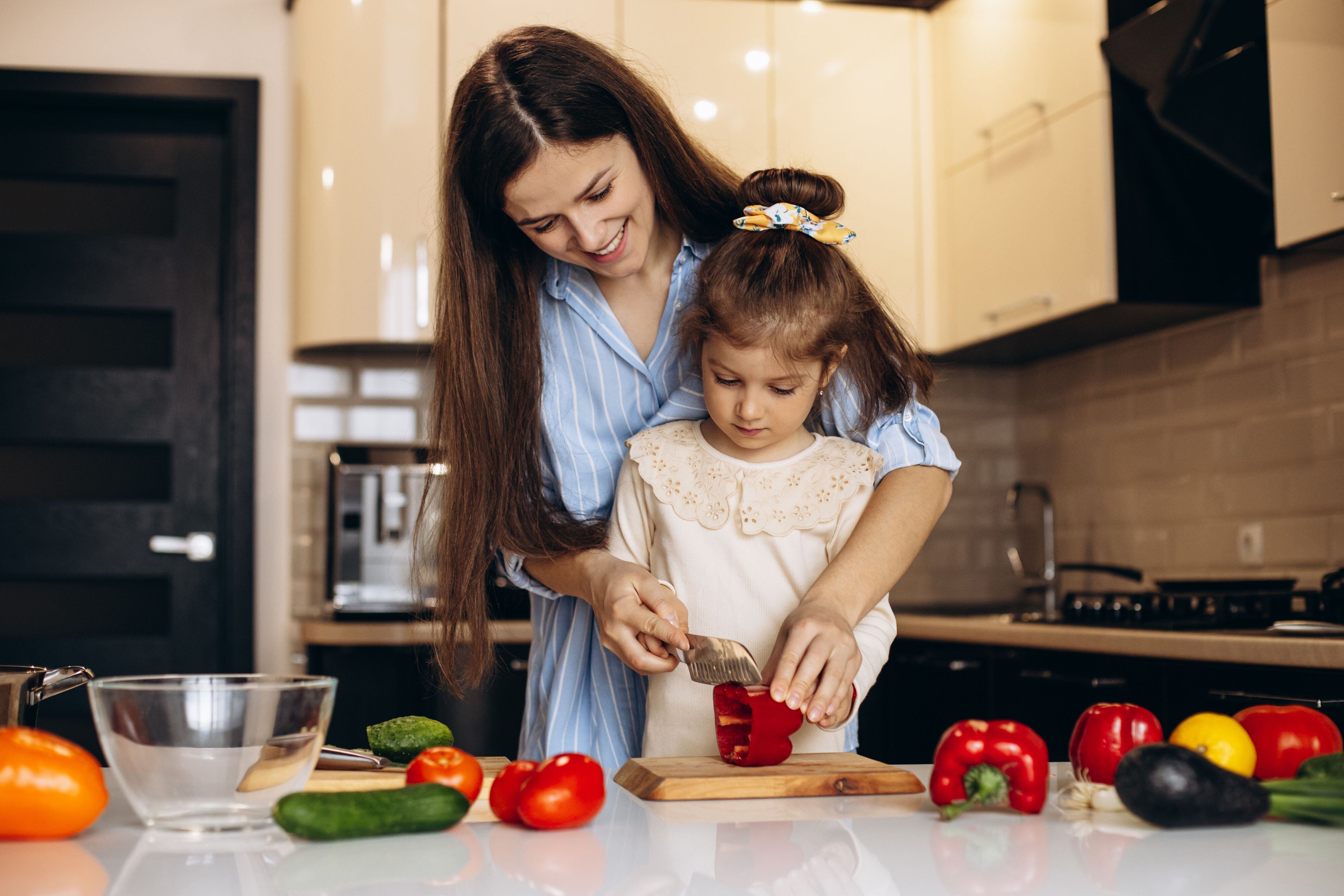 habitos saludables niños alimentación saludable madre-hija-preparando-ensalada-verduras-frescas-cocina Credito Freepik