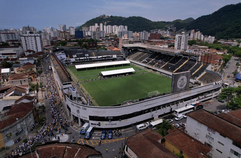 Los dolientes presentan sus respetos al pasar por el ataúd de la leyenda del fútbol brasileño Pelé mientras yace en el campo de su antiguo club, el Santos, en el estadio Vila Belmiro de Santos, Brasil. 2 de enero, 2023. REUTERS/Amanda Perobelli