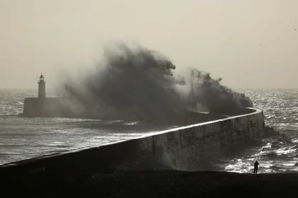 Una persona ve cómo grandes olas golpean la pared del puerto al tomar el sol durante la tormenta Isha en Newhaven, sur de Gran Bretaña, el 22 de enero de 2024. REUTERS/Toby Melville
