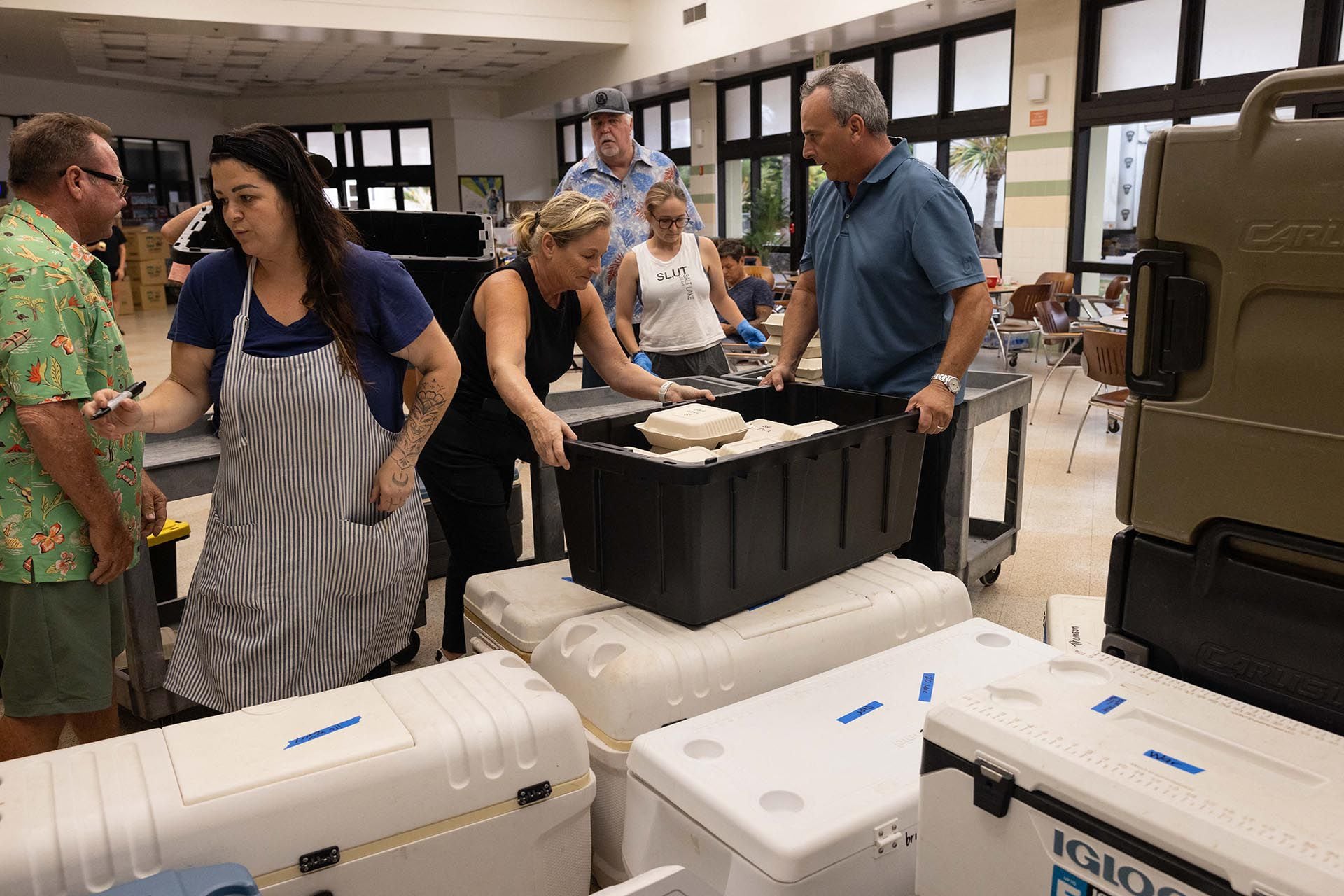 Miembros del Ejército de Salvación y otras redes de voluntarios recogen los alimentos, que llegan a los refugios y a Lahaina aún calientes. (Foto por Yuki IWAMURA / AFP)