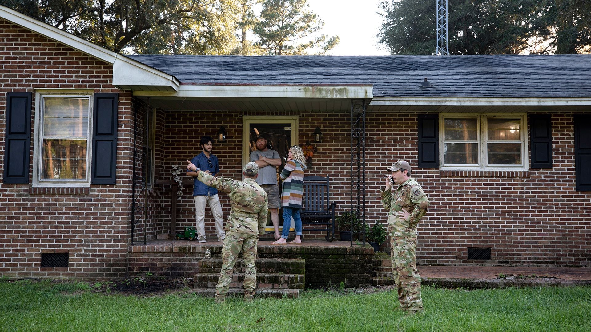 Aviadores de la Base Conjunta de Charleston hablan con una familia que vive justo al lado del lugar donde se estrelló un F-35 sobre la operación para recuperar el caza (Henry Taylor/The Post And Courier via AP)