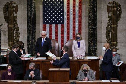 El vicepresidente de Estados Unidos, Mike Pence, y la presidenta de la Cámara de Representantes, Nancy Pelosi (D-CA), leyeron la certificación final de los votos del Colegio Electoral emitidos en las elecciones presidenciales de noviembre durante una sesión conjunta del Congreso después de trabajar toda la noche, en el Capitolio de Washington DC, EEUU. 7 de enero de 2021. J. Scott Applewhite/Pool vía REUTERS