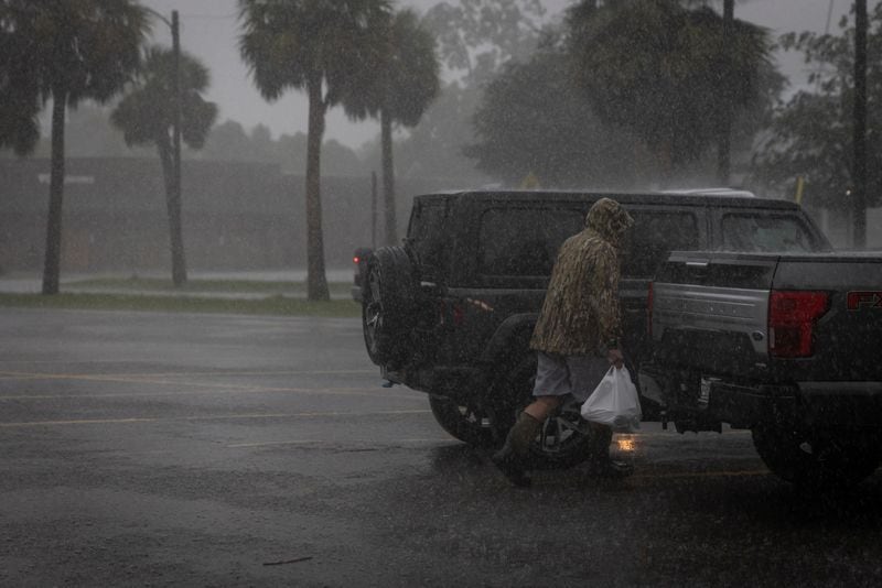 Un hombre camina bajo la lluvia con bolsas de comestibles mientras el huracán Helene se intensifica antes de su esperada llegada a tierra en el Big Bend de Florida, en Apalachicola, Florida, Estados Unidos. 26 de septiembre de 2024.  REUTERS/Marco Bello