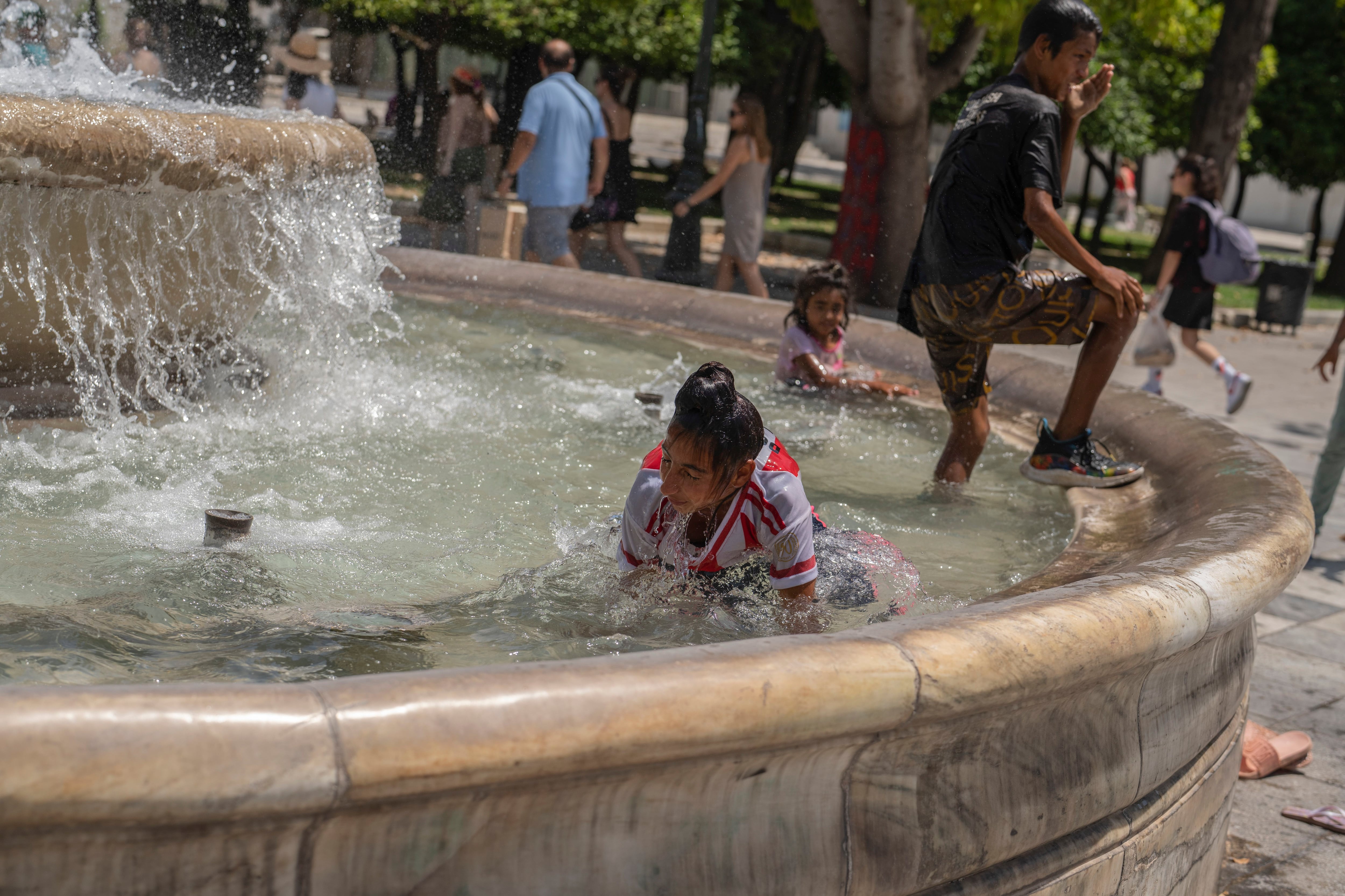 En la plaza Syntagma, en Atenas, los niños nadaron en una fuente para afrontar un nuevo día de 44 grados de máxima (AP)
