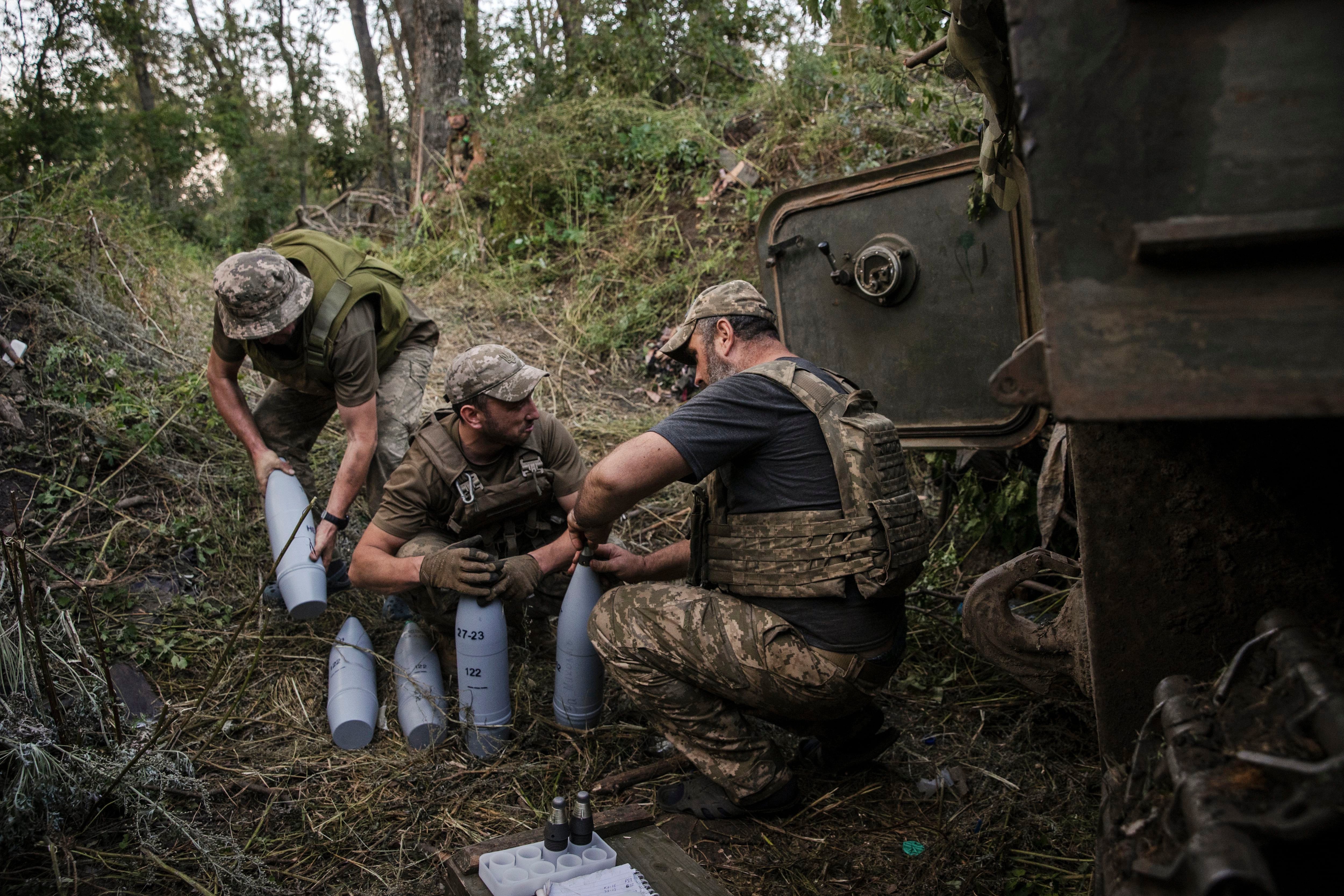 Soldados ucranianos con un reabastecimiento de artillería para su obús de 122 milímetros en la región ucraniana de Bakhmut, el 28 de agosto de 2023 (Tyler Hicks/The New York Times)