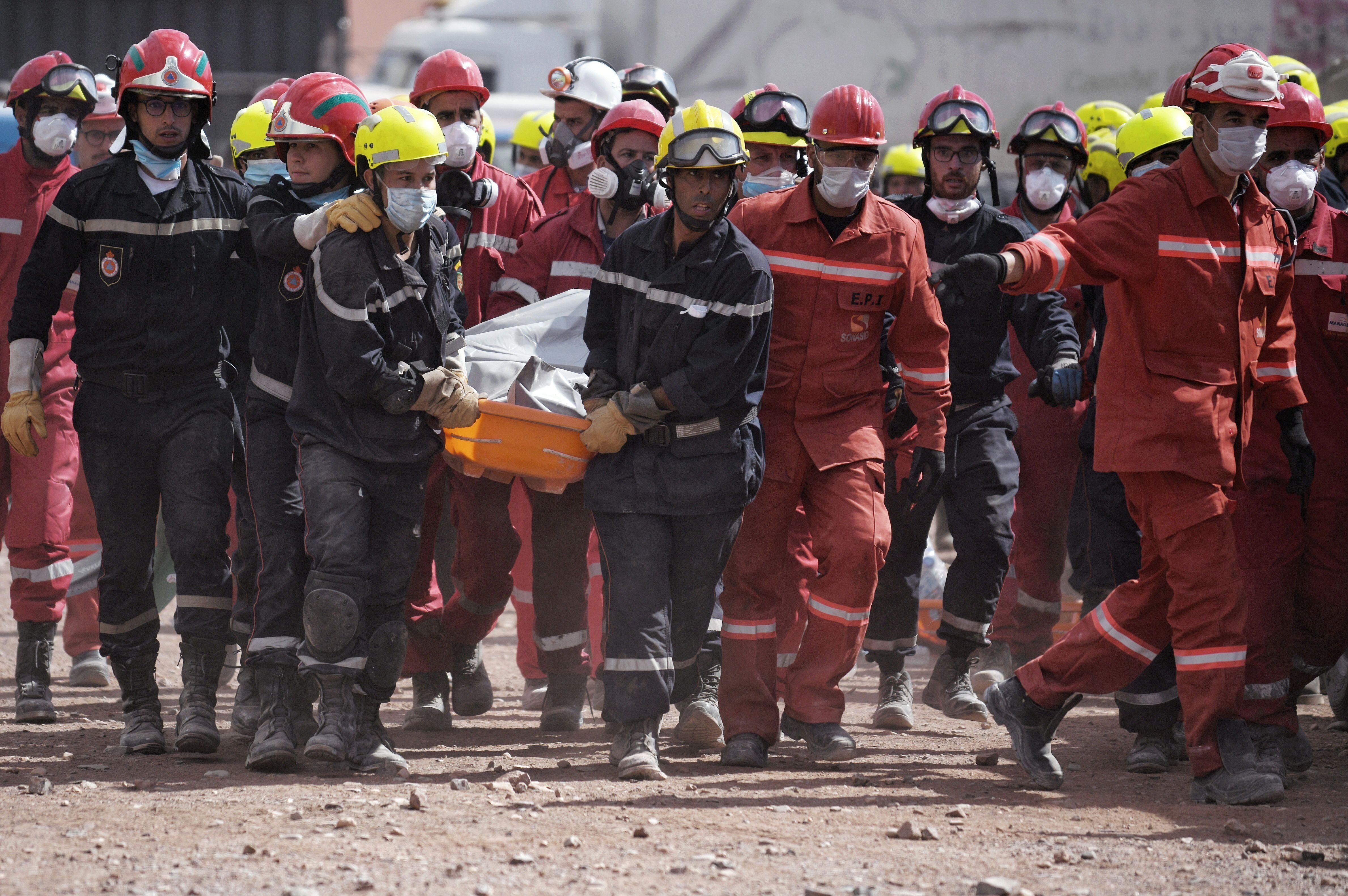 Un grupo de bomberos lleva el cuerpo de una persona fallecida  (Foto: Europa Press)