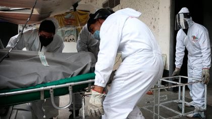 Fotografía del 28 de abril de 2020 que muestra a los trabajadores del crematorio recibiendo el cuerpo de una persona que murió de COVID-19, en un cementerio de la Ciudad de México (México).  EFE / Sáshenka Gutiérrez / Archivo