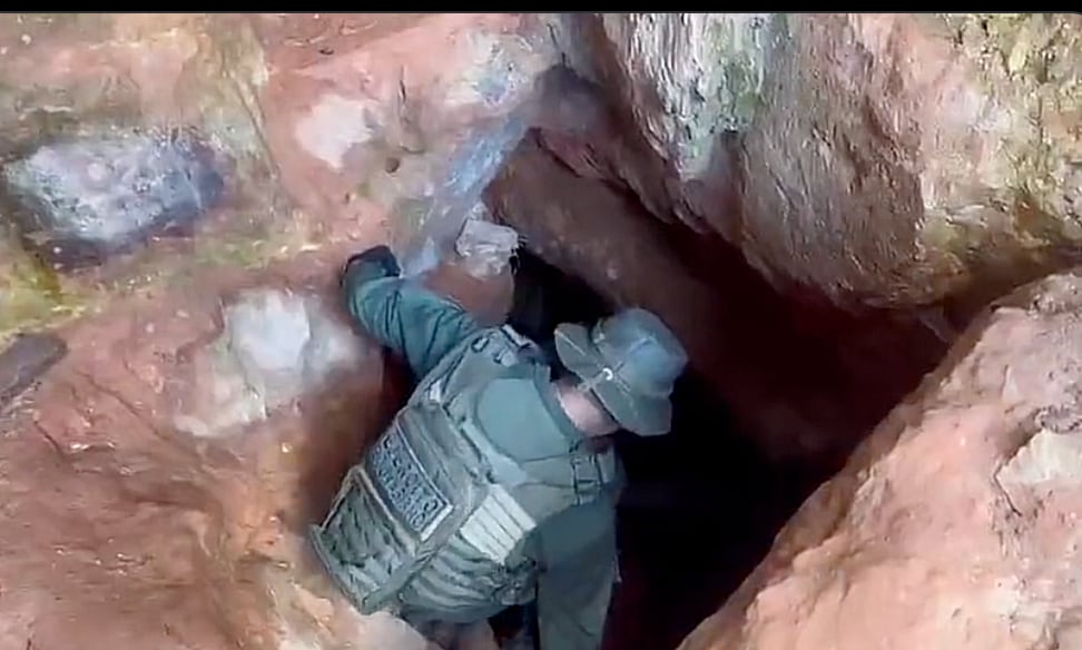 Un funcionario del Ejército baja por un de las grunas o túneles de galería que abren  los mineros 