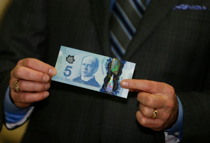 El gobiernador del Banco de Canadá, Stephen Poloz, presenta un billete de cinco dólares canadienses hecho de polímeros, Agencia Espacial de Canadá, St. Hubert, Quebec, Canadá, 7 noviembre 2013.
REUTERS/Christinne Muschi