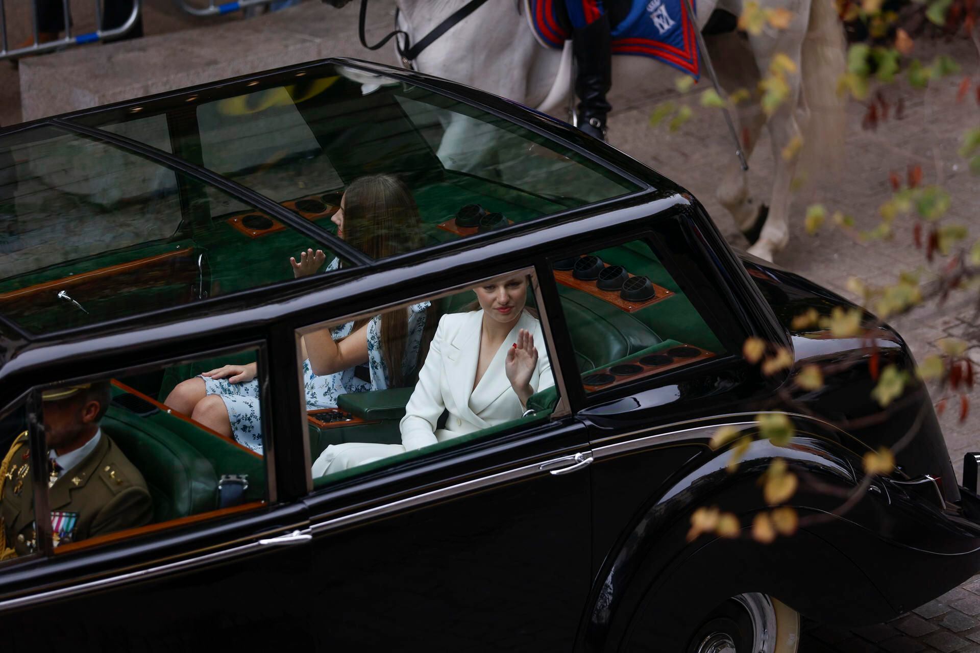 La princesa Leonor y la infanta Sofía a bordo del Rolls Royce Phamton IV escoltadas por la Guardia Real Motorizada saludan a los ciudadanos a su paso por la calle Mayor en su trayecto hacia el Congreso de los Diputados, donde este martes tiene lugar la jura de la Constitución de la Princesa de Asturias por su mayoría de edad ante las Cortes Generales, en una solemne sesión conjunta de las dos cámaras legislativas que se celebra este martes en el hemiciclo de la Cámara Alta. EFE/Rodrigo Jiménez