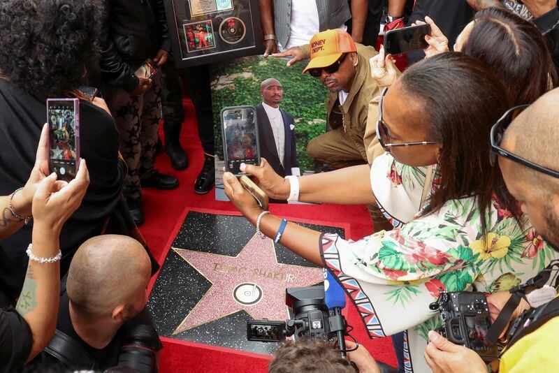 Un grupo personas toma fotos de la estrella del rapero Tupac Shakur durante la ceremonia póstuma de develación en el Paseo de la Fama de Hollywood en Los Ángeles, California, EEUU, el 7 de junio de 2023 (REUTERS/Mario Anzuoni)