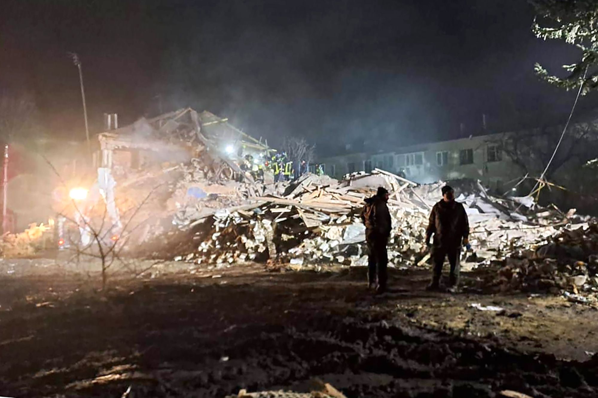 Bomberos examinan el lugar donde un misil ruso alcanzó un edificio de apartamentos en la región de Kharkiv, Ucrania, el 15 de febrero de 2024 (AP)