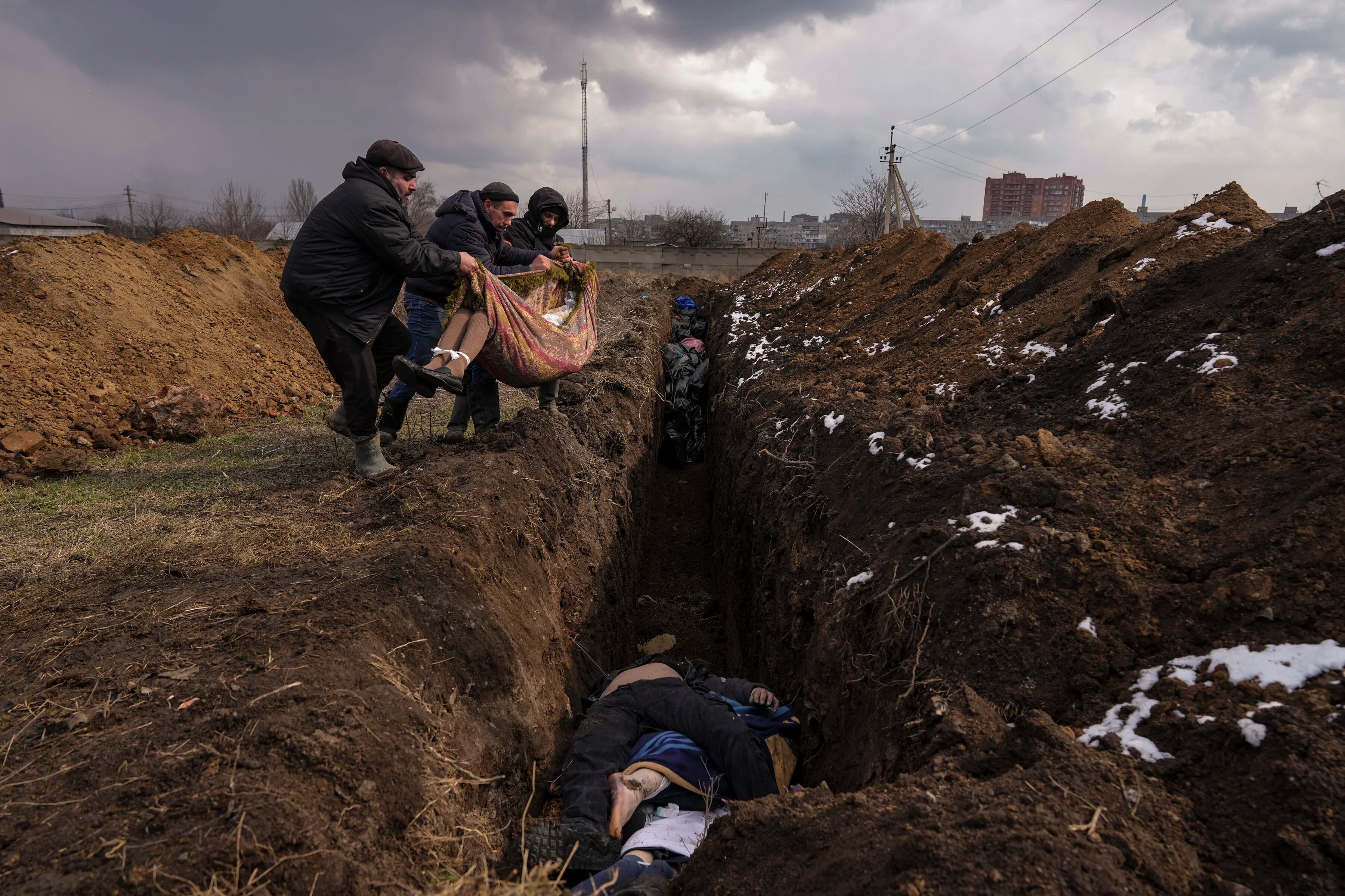Los cuerpos son colocados en una fosa común en las afueras de Mariupol, Ucrania, el miércoles 9 de marzo de 2022.