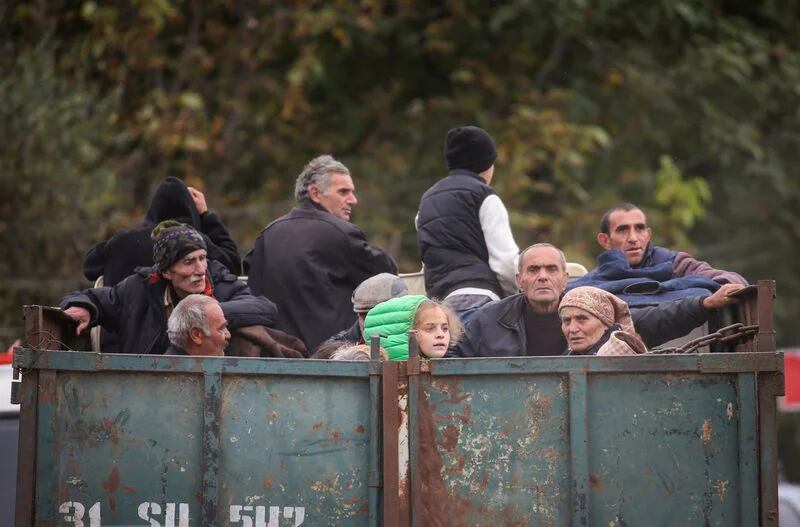 Refugiados de la región de Nagorno Karabaj viajan en la parte trasera de un camión a su llegada al pueblo fronterizo de Kornidzor, Armenia. 26 de septiembre de 2023. REUTERS/Irakli Gedenidze