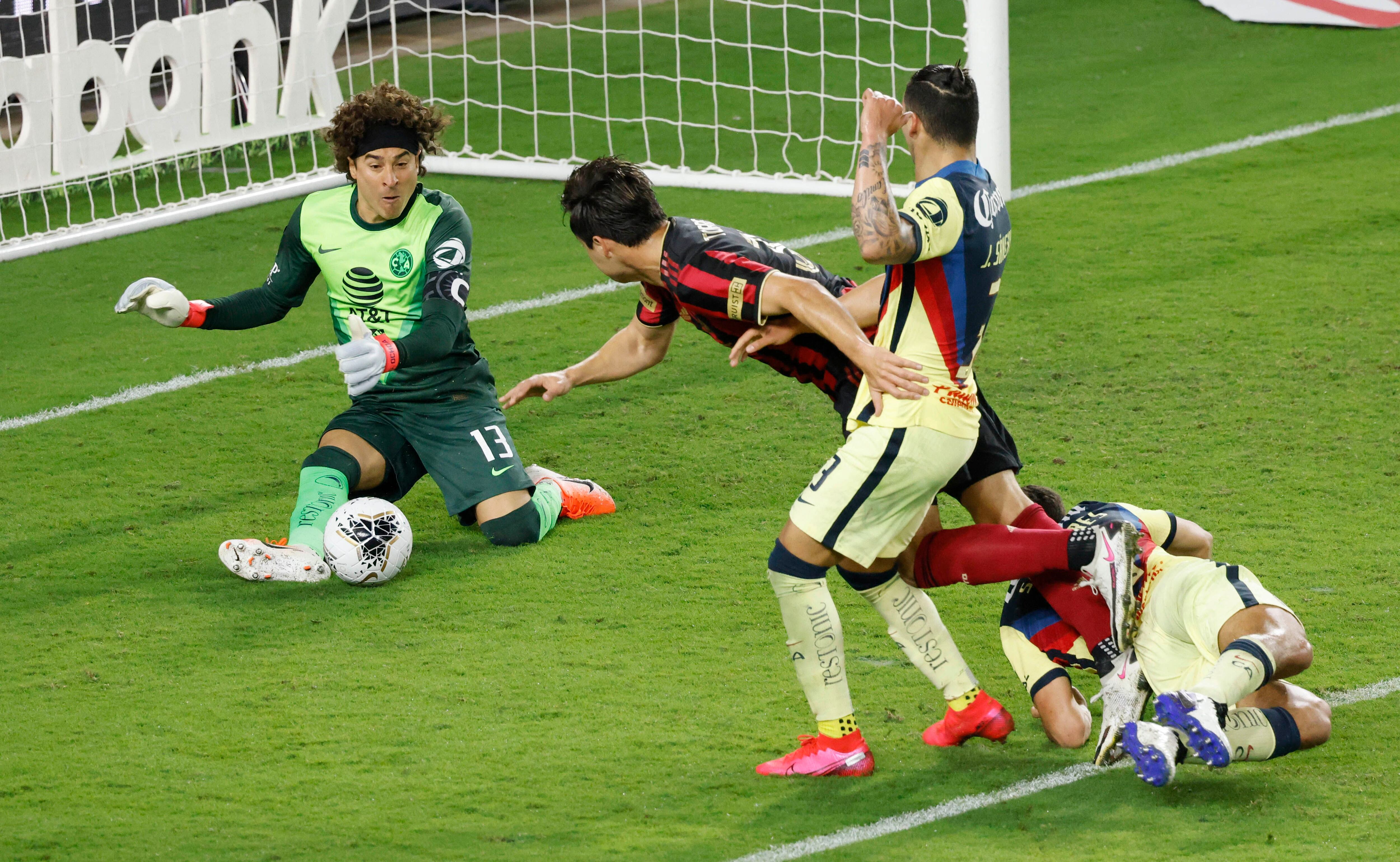 Dec 16, 2020; Orlando, Florida, USA; Club America goalkeeper Guillermo Ochoa (13) saves the ball against Atlanta United forward Erick Torres (left center) as Club America defender Jorge Sanchez (right center) and defender Sebastian Caceres (4) look on in the second half during the 2020SCCL quarterfinals at Exploria Stadium. Mandatory Credit: Reinhold Matay-USA TODAY Sports