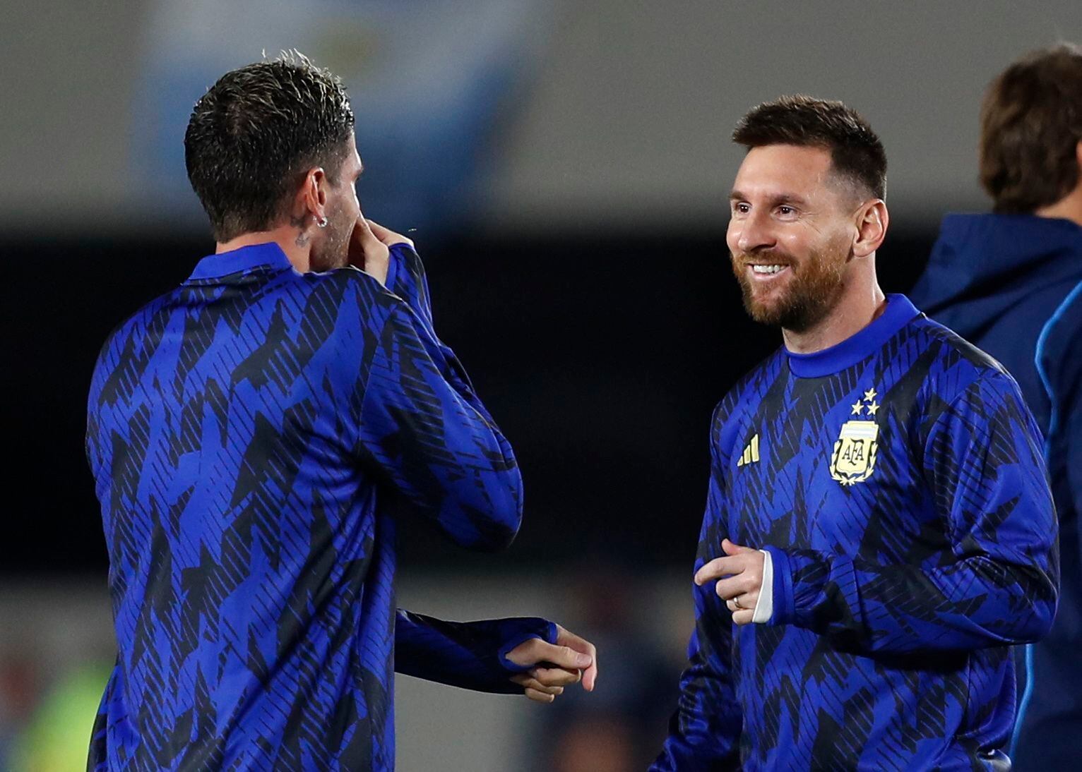 Lionel Messi dialoga con Rodrigo De Paul en la entrada en calor. El astro será suplente ante Paraguay (REUTERS/Agustin Marcarian)