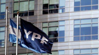 Una bandera de la empresa petrolera YPF ondea junto a una bandera argentina frente a la sede de la empresa, en Puerto Madero (REUTERS/Marcos Brindicci)