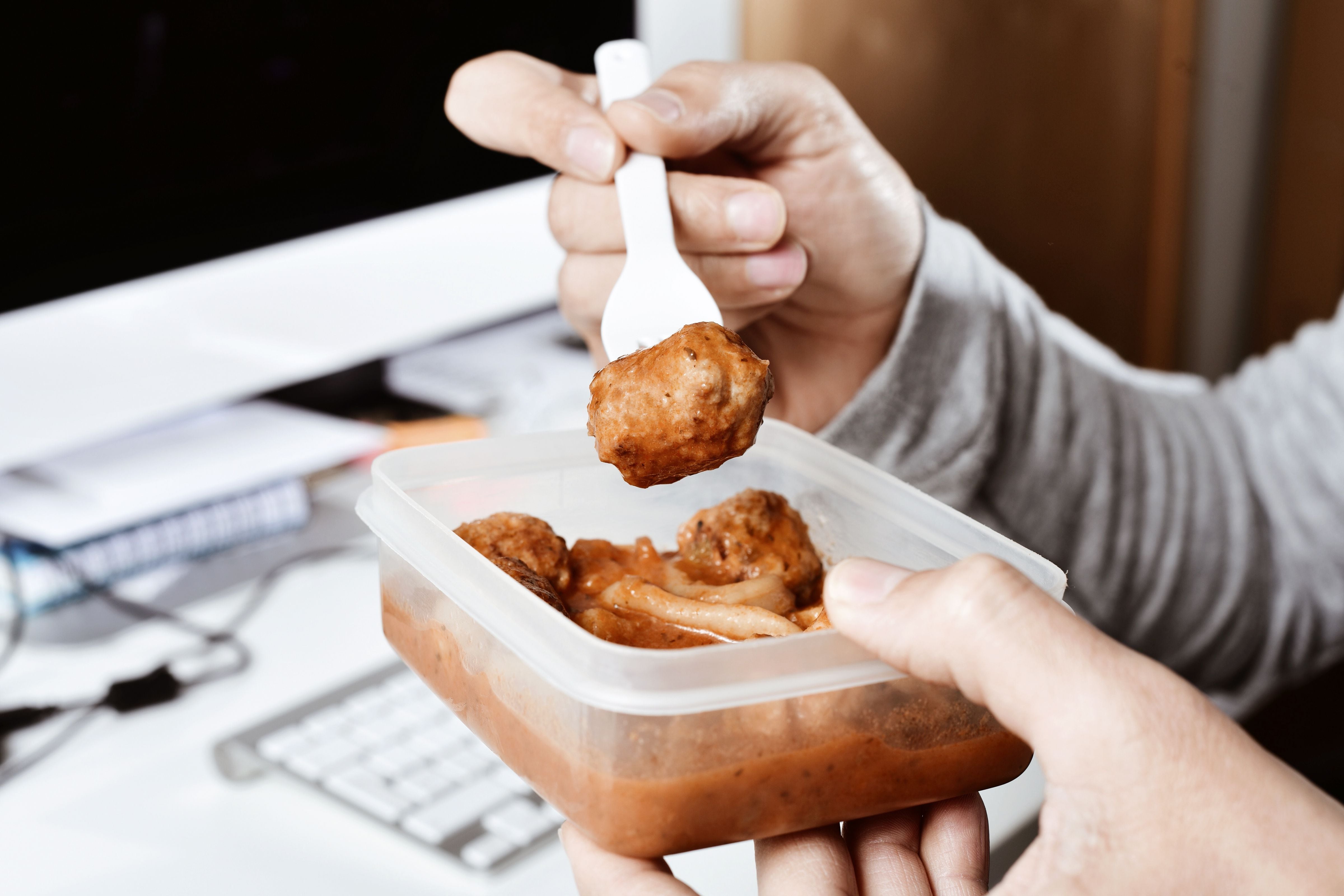 Una persona comiendo táper en el trabajo (Shutterstock España)