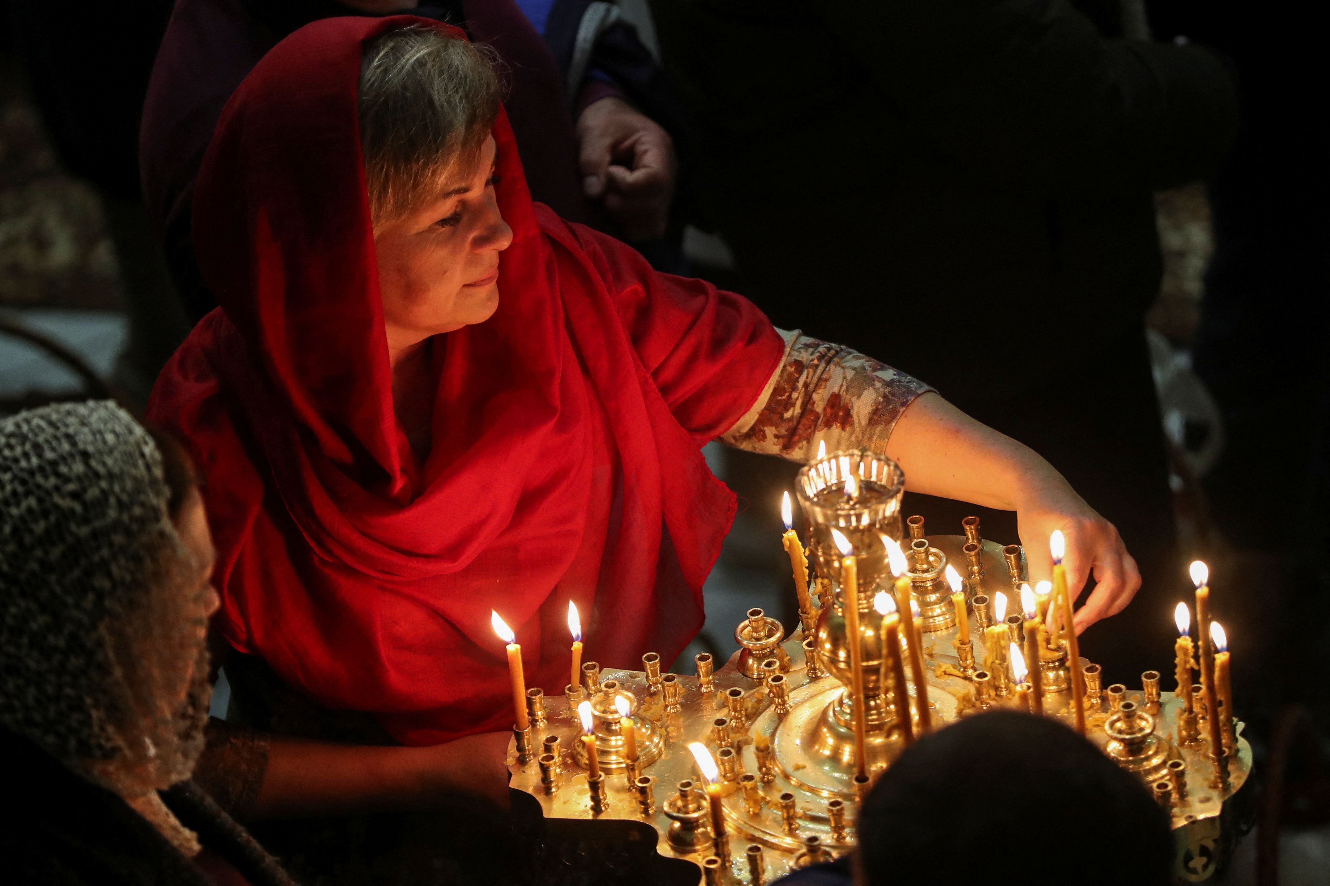 Una mujer coloca una vela durante un servicio religioso ortodoxo de Pascua en la Iglesia de Todos los Santos de Chernihiv (REUTERS/Maksym Muzychenko-Kishka)