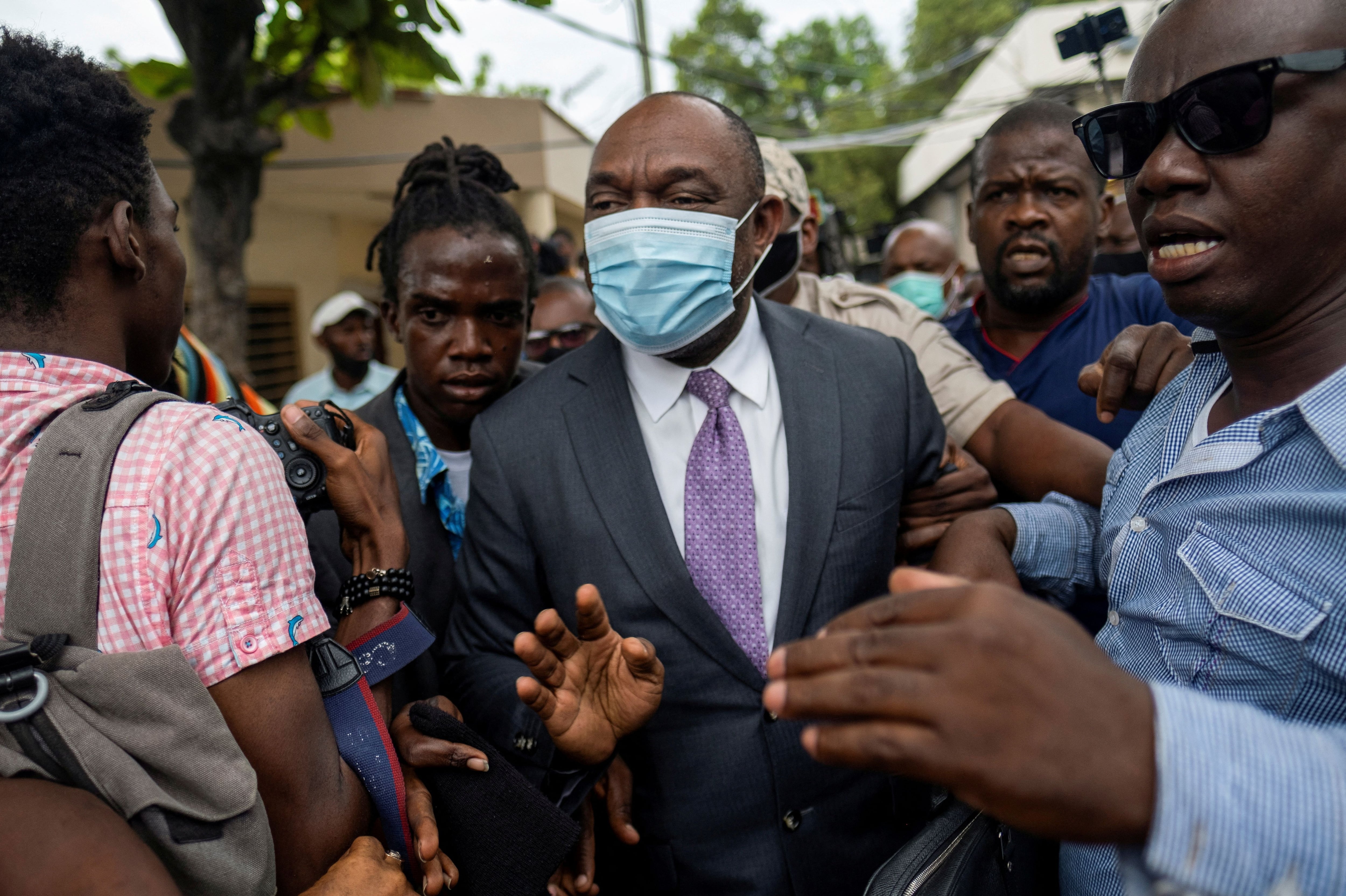 El ex senador Youri Latortue es escoltado por guardaespaldas fuera de la corte después de una audiencia tras el asesinato del presidente Jovenel Moise, en Puerto Príncipe, Haití, el 12 de julio de 2021 (REUTERS/Ricardo Arduengo)