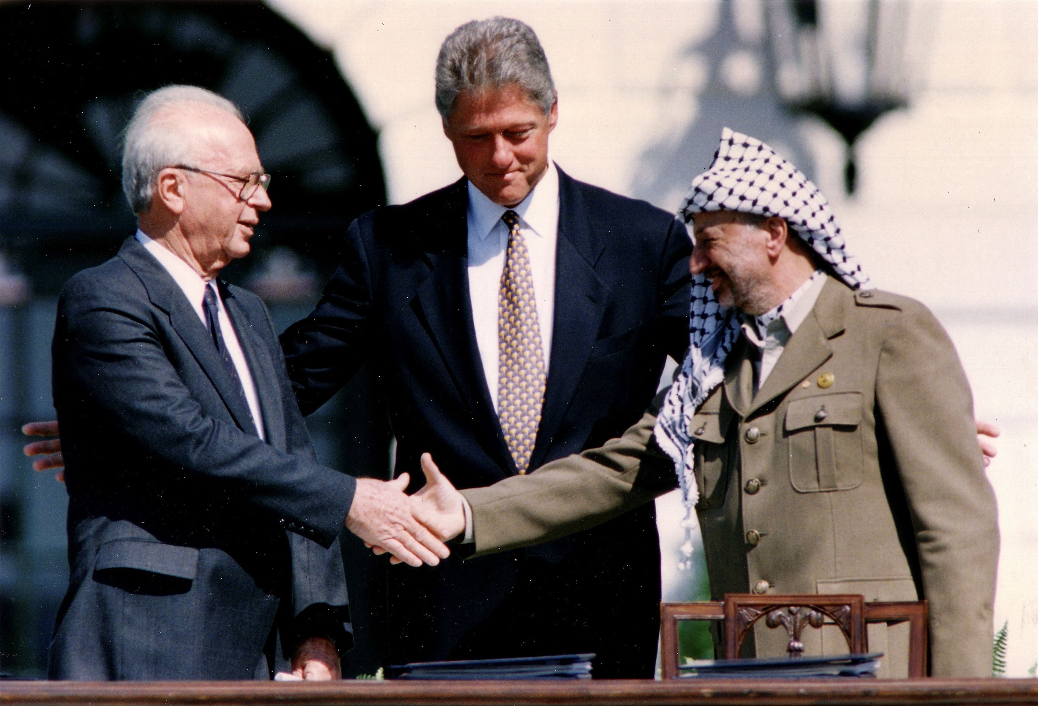 En septiembre de 1993, Israel y Palestino firmaron los acuerdos de Oslo en Washington: en la imagen se estrechan la mano el entonces primer ministro israelí, Yitzhak Rabin, con el ex líder de la OLP palestina, Yasser Arafat, frente a Bill Clinton (REUTERS/Gary Hershorn)