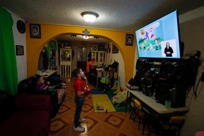 Santi, 6, follows a televised kindergarten lesson in his home as students return to classes but not schools in Mexico City, Monday, Aug. 24, 2020. A system cobbling together online classes, instruction broadcast on cable television channels and radio programming in indigenous languages for the most remote, will attempt to keep students from missing out. (AP Photo/Rebecca Blackwell)