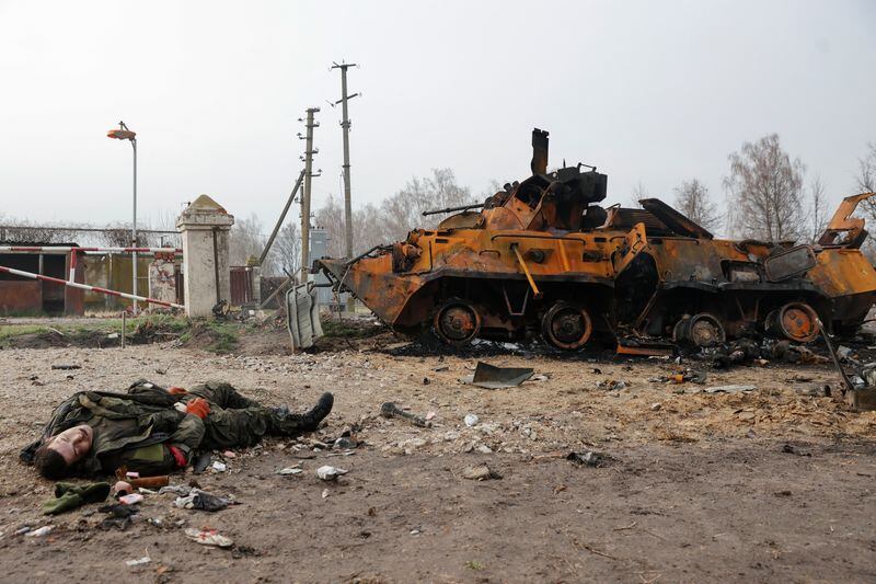 El cuerpo de un soldado ruso muerto yace en el suelo frente a un vehículo blindado ruso BTR-82 destruido, en la región de Chernigov (REUTERS/Serhii Nuzhnenko)