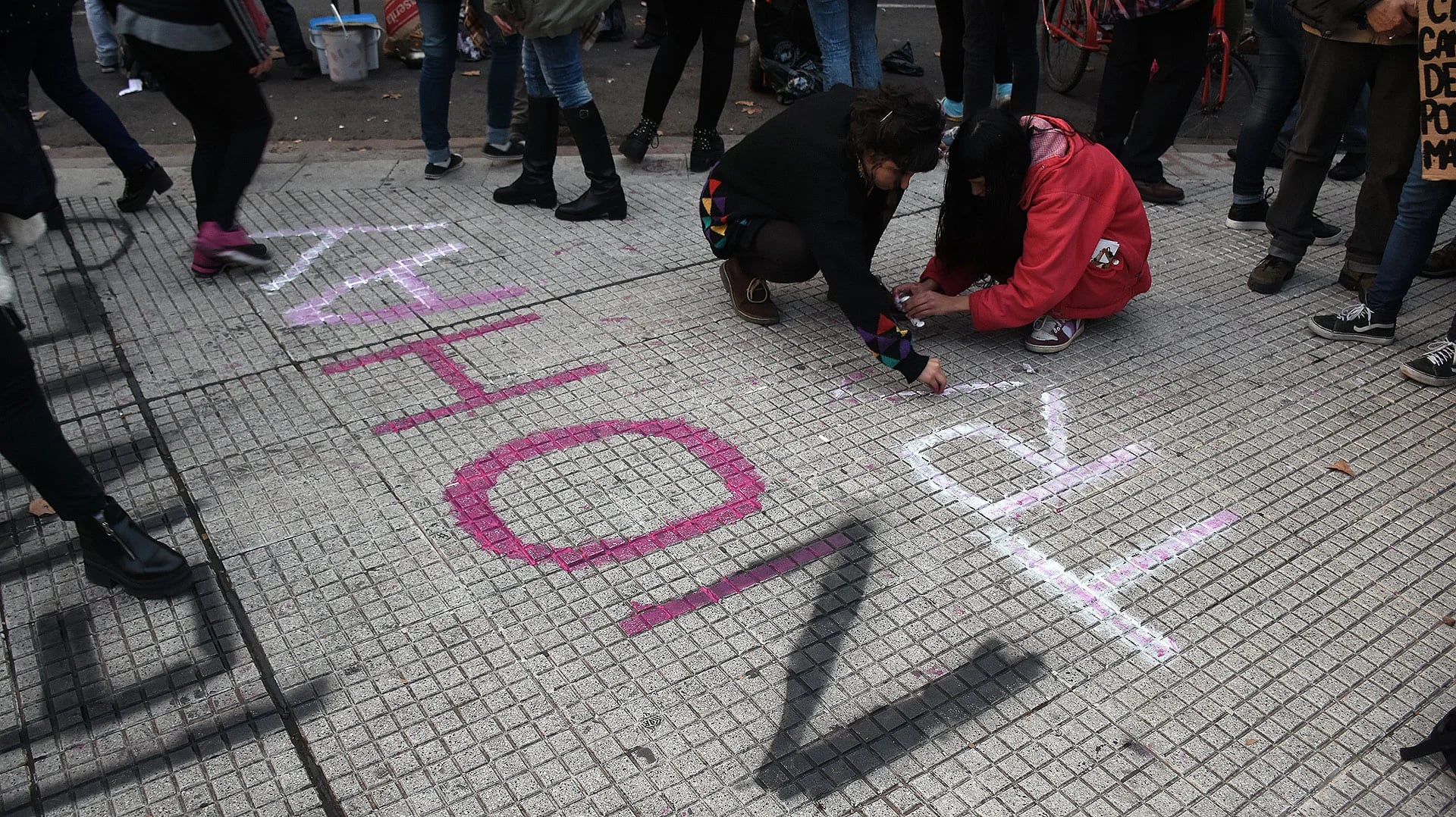 Unas manifestantes escriben en las baldosas: “sin clientes no hay trata” (Nicolás Stulberg)