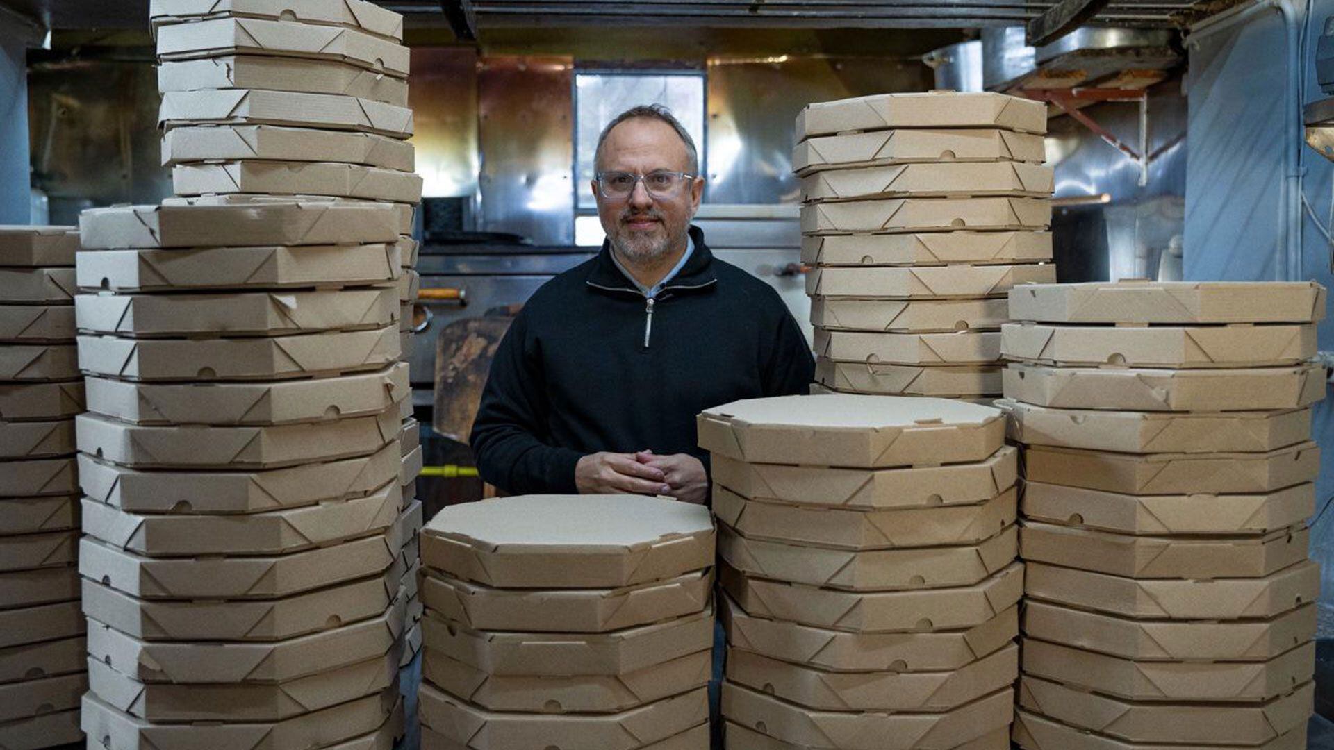 Diego Valenzuela de Tres de Febrero junto a una montaña de pizzas