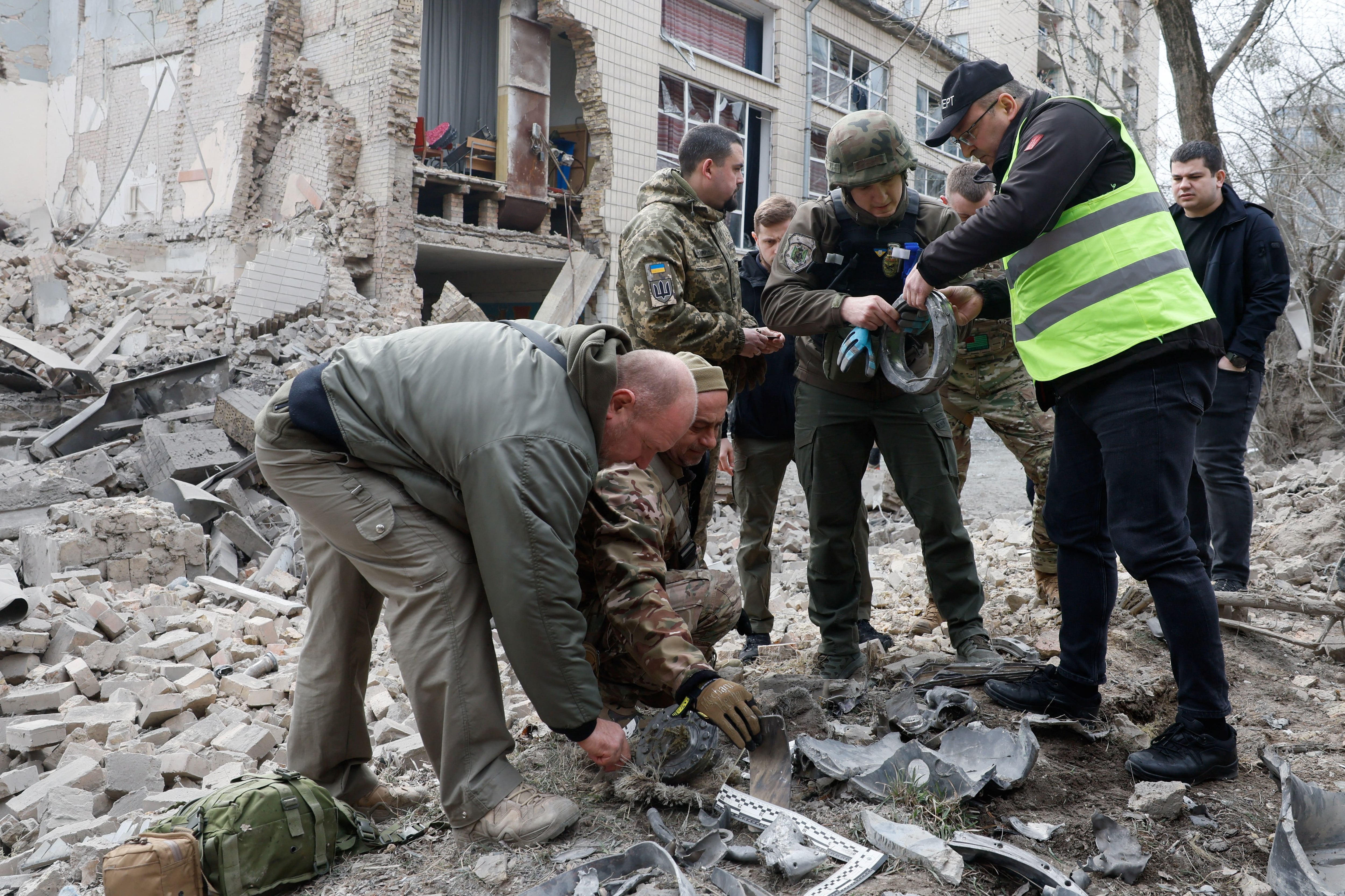 Expertos policiales trabajan entre los restos del ataque ruso sobre Kiev (REUTERS/Gleb Garanich)