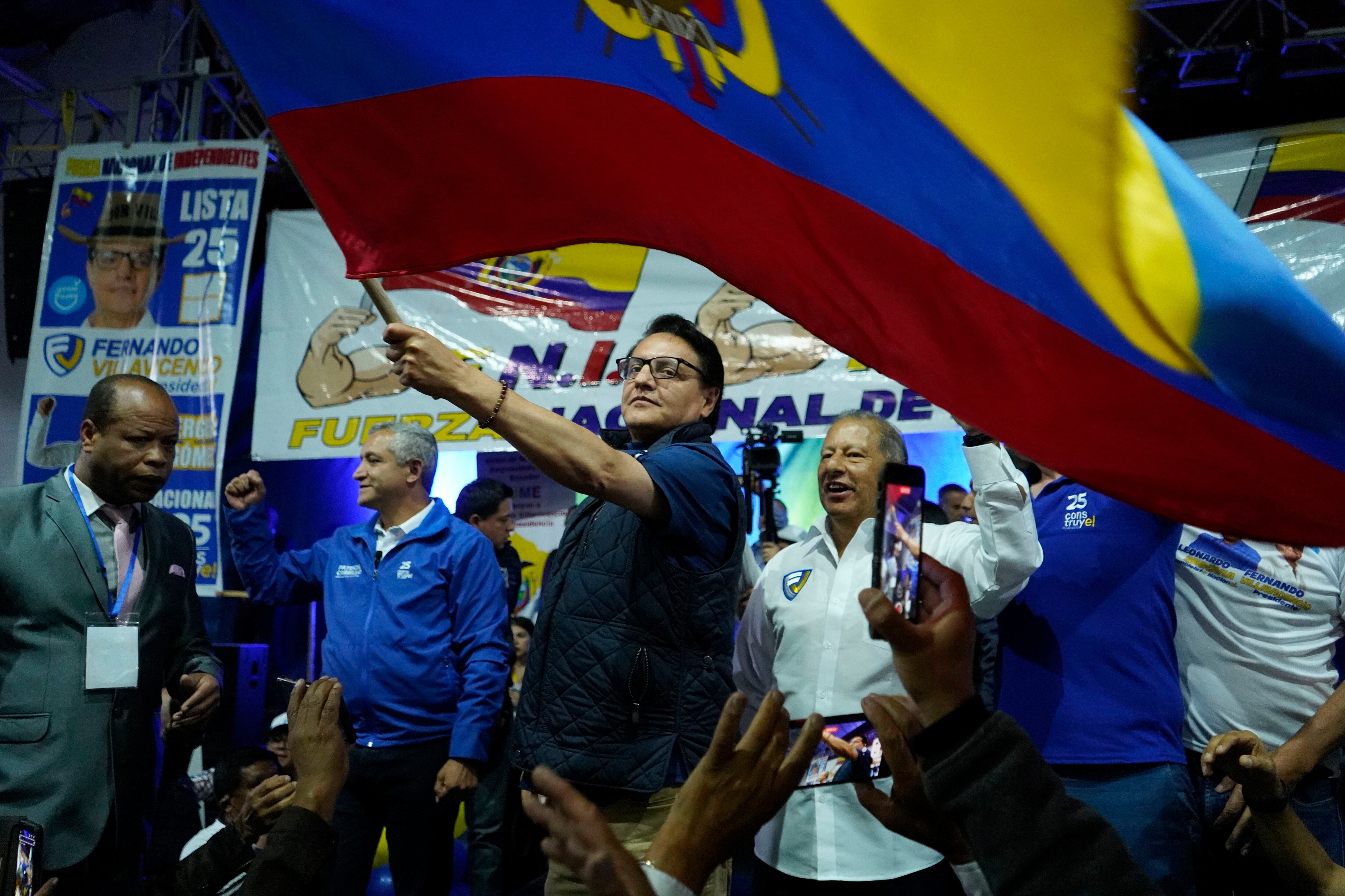 El entonces candidato presidencial Fernando Villavicencio ondeando una bandera nacional durante un evento de campaña en una escuela minutos antes de que lo mataran a tiros en Quito, Ecuador, el 9 de agosto de 2023. (AP vía AP/Archivo)