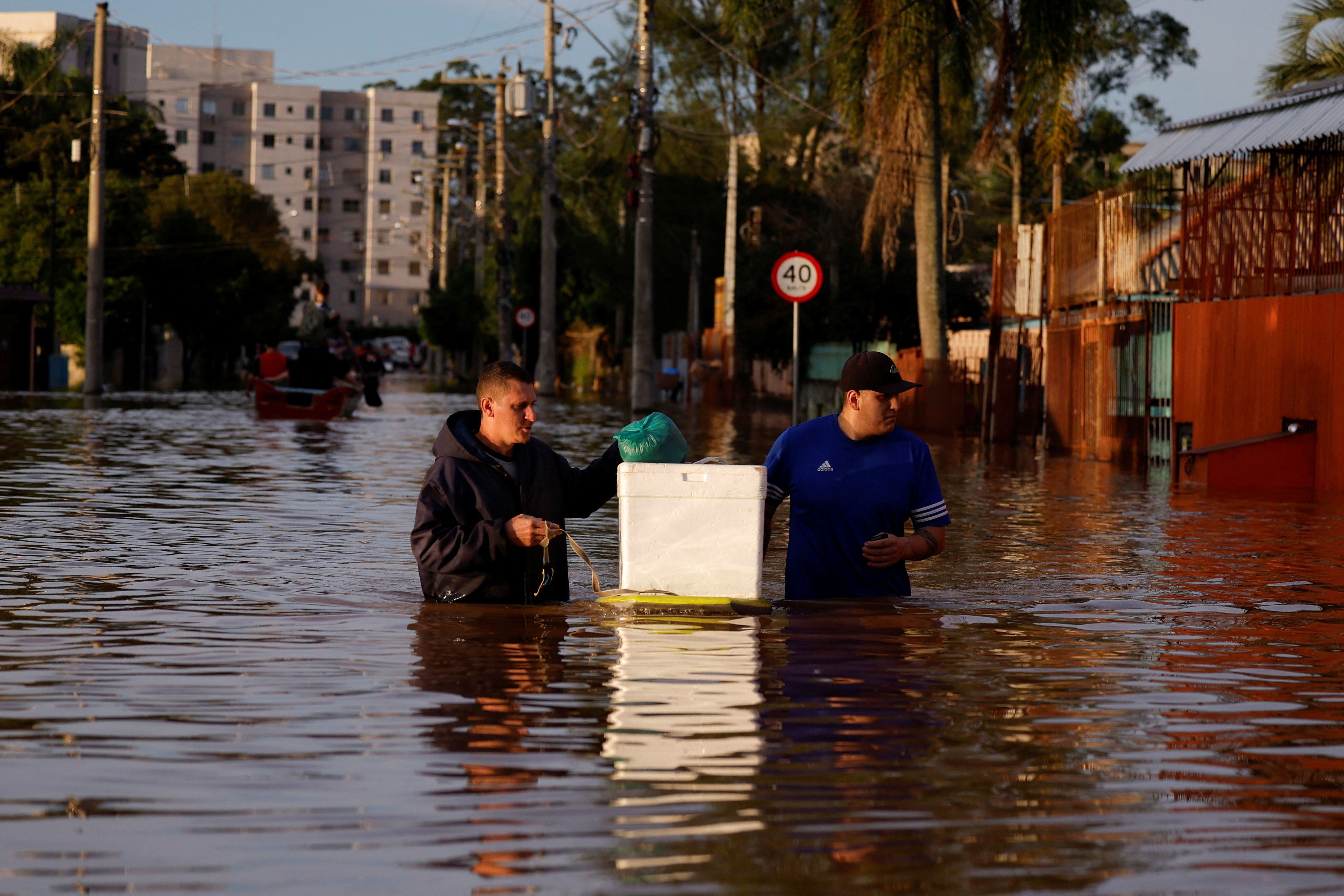 People wade through flood waters in Canoas, at the Rio Grande do Sul state, Brazil, May 5, 2024. REUTERS/Amanda Perobelli