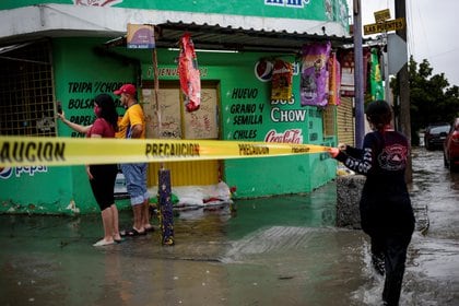 Un rescatista coloca una cinta amarilla de advertencia durante la tormenta Hanna en San Nicolás de los Garza, en las afueras de Monterrey, México, el 26 de julio de 2020. REUTERS / Daniel Becerril