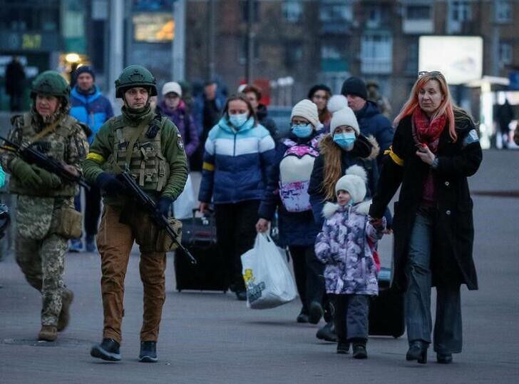 Fuerzas de seguridad escoltando a familias en un tren para ser evacuadas desde Kiev  