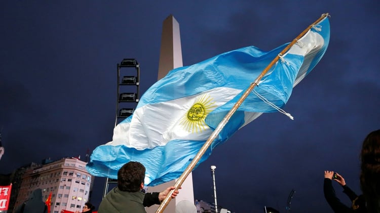 Una bandera argentina flamea al pie del Obelisco porteños, durante un cacerolazo en 2018 (Reuters)