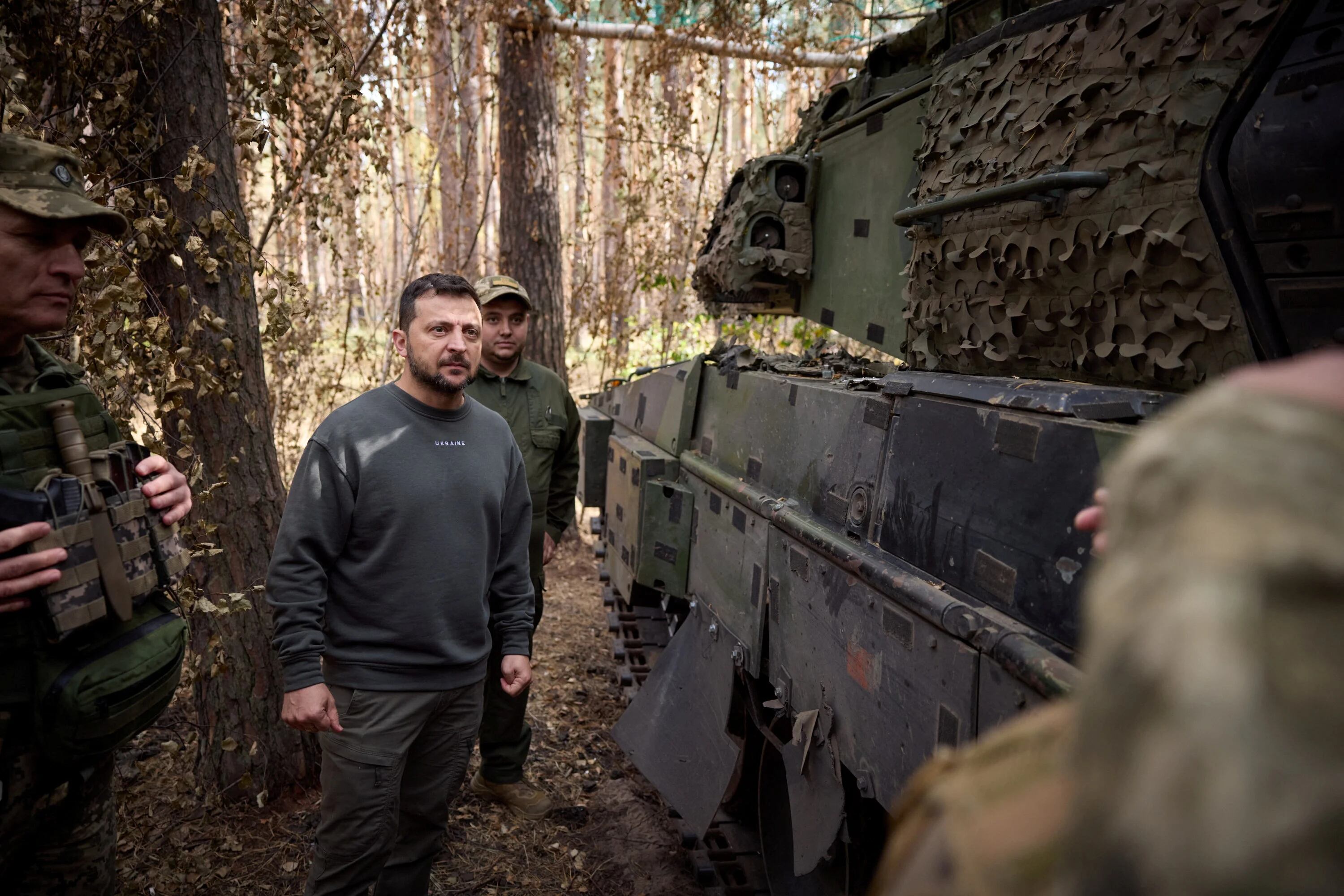Ukraine's President Volodymyr Zelenskiy stands next to a Swedish CV90 armoured fighting vehicle as he visits a position of Ukrainian troops in a front line, amid Russia's attack on Ukraine, in an undisclosed location, Ukraine October 3, 2023. Ukrainian Presidential Press Service/Handout via REUTERS ATTENTION EDITORS - THIS IMAGE HAS BEEN SUPPLIED BY A THIRD PARTY.