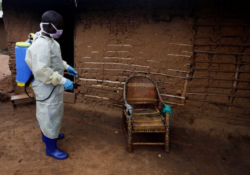 Kavota Mugisha Robert, un trabajador sanitario que se ofreció como voluntario en la respuesta al virus del Ébola, descontamina una silla que usaba una mujer de 85 años, sospechosa de haber muerto a causa del brote, frente a su casa en la ciudad de Beni, en el este de la República Democrática del Congo, el 8 de octubre de 2019. REUTERS/Zohra Bensemra