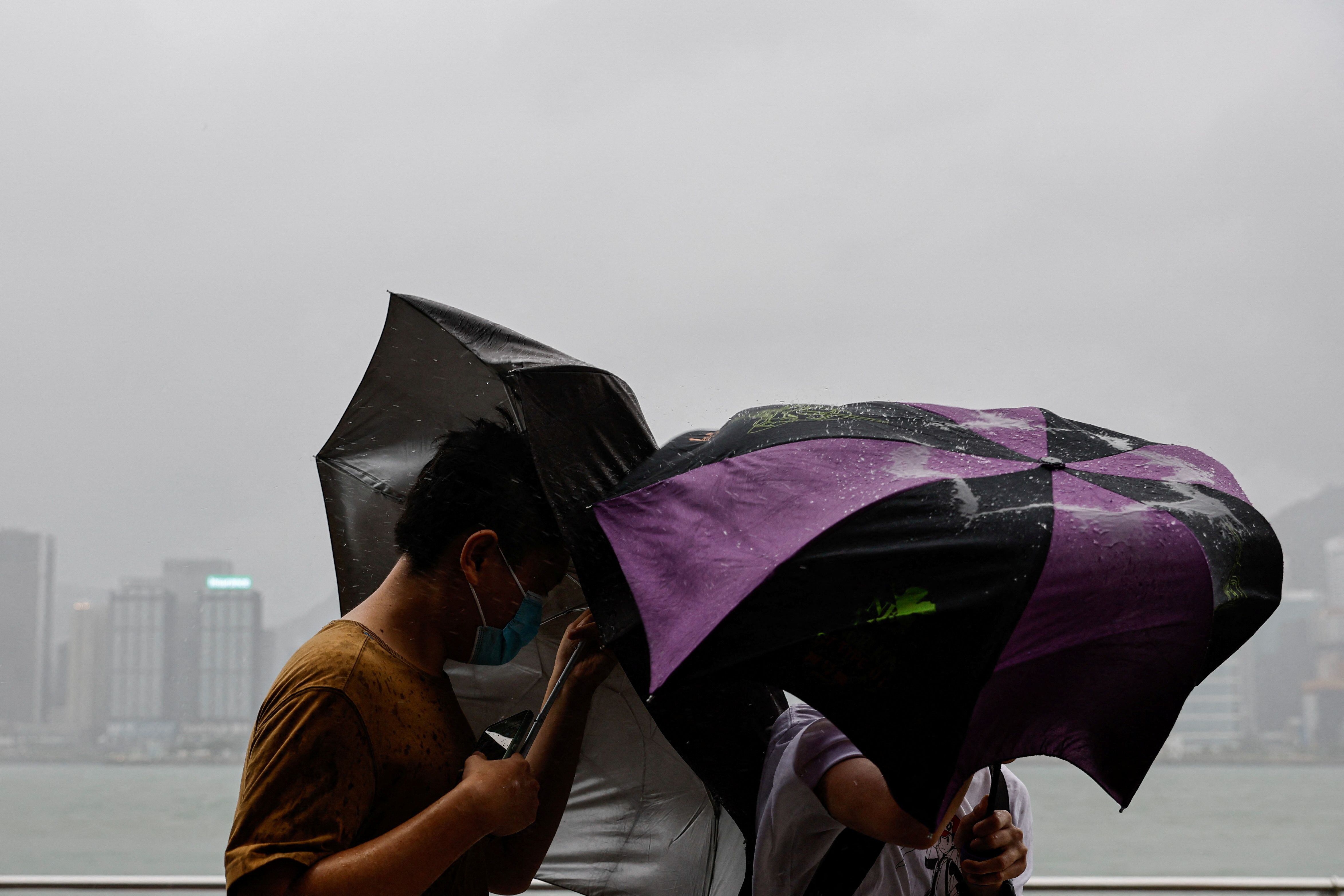 Un grupo de personas hace frente a fuertes vientos mientras se aproxima el supertifón Saola, en Hong Kong, China, el 1 de septiembre de 2023. REUTERS/Tyrone Siu