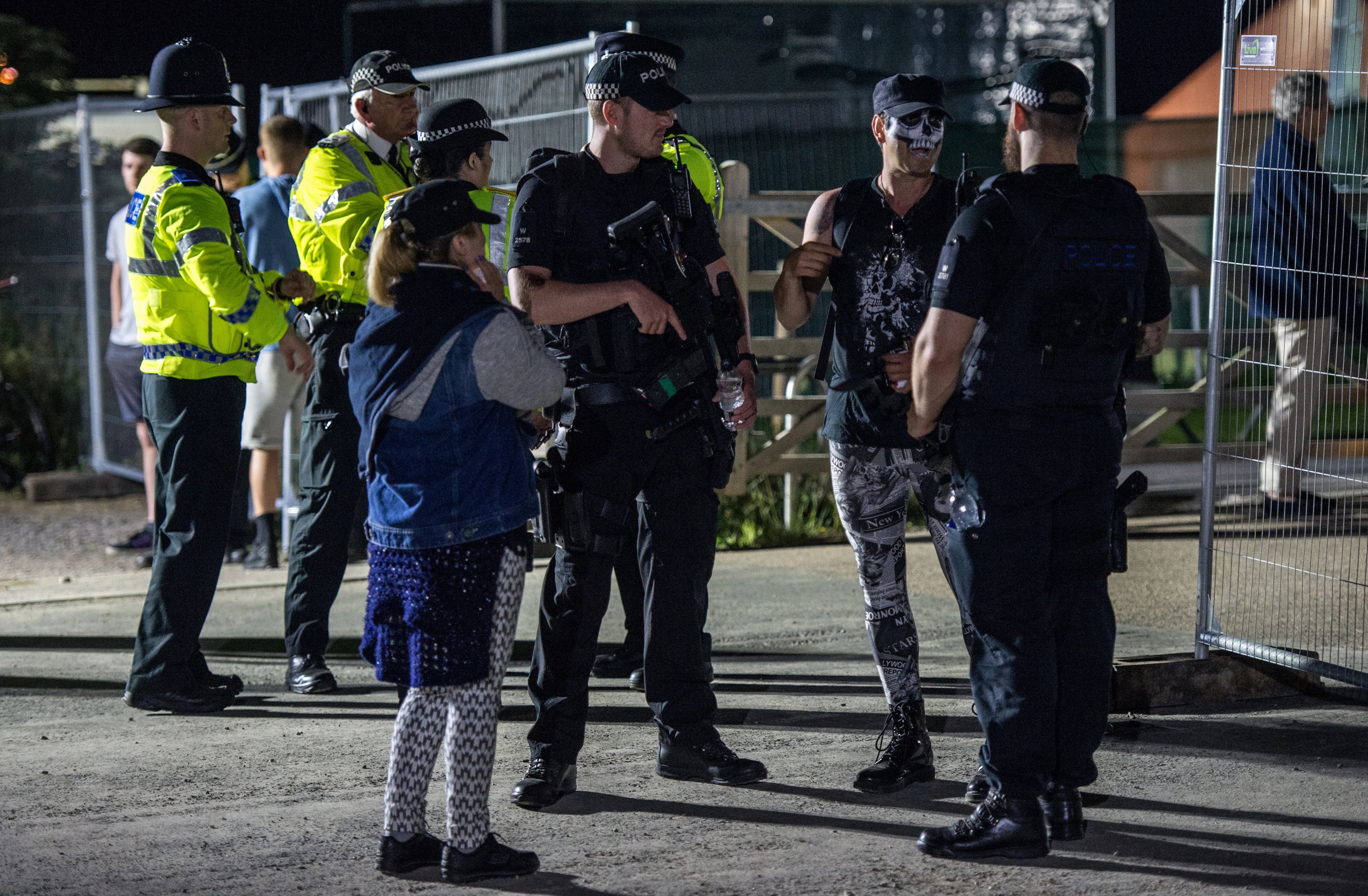 Un asistente conversa con la policía, fuertemente armada en medio de un operativo inusual provocado por los recientes ataques terroristas en Manchester y Londres (AFP)