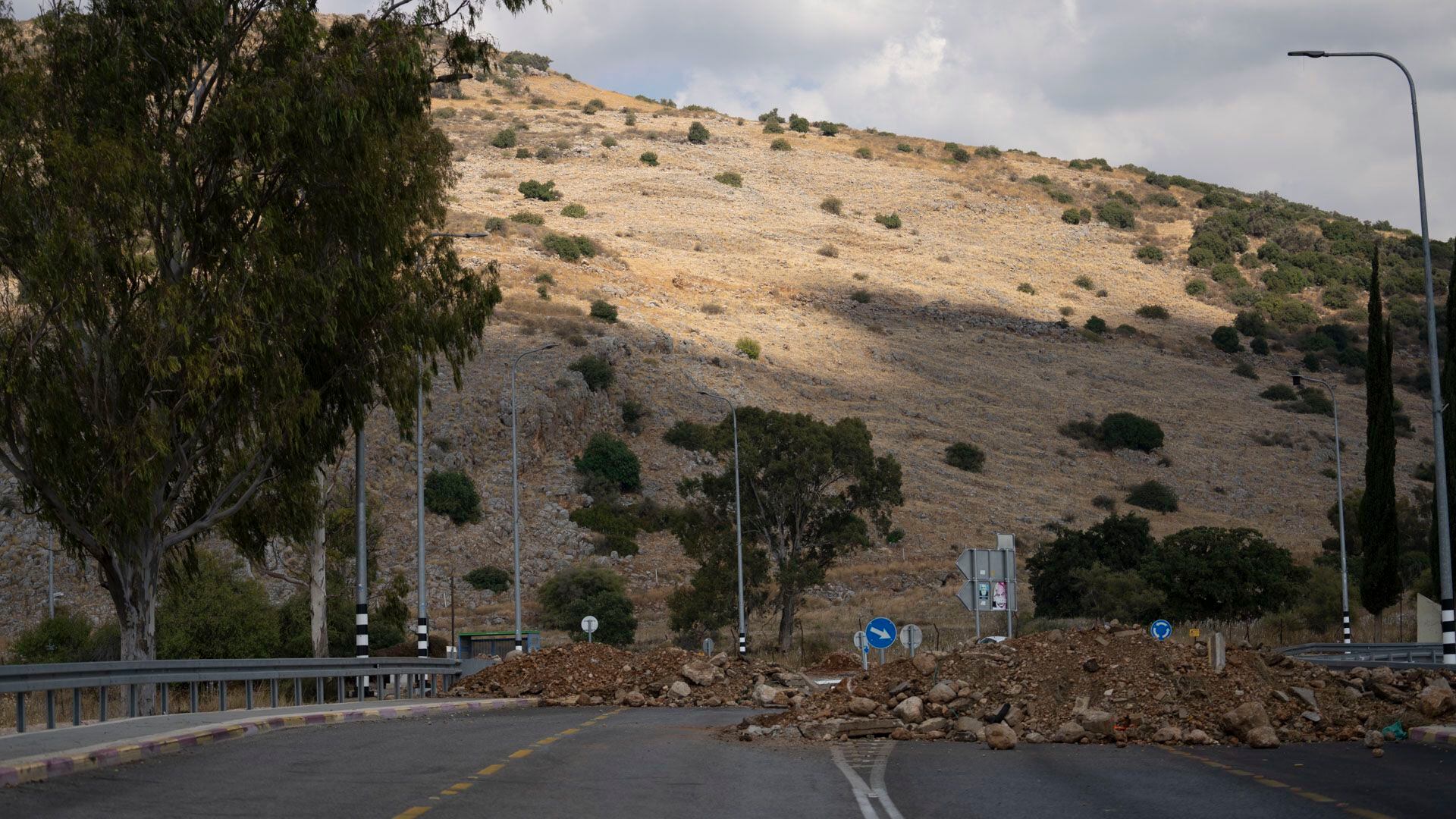 Un camino vacío y un bloqueo físico con escombros y piedras para trabar una eventual circulación en las cercanías de los pequeños pueblos que están bajo el fuego de Hezbollah