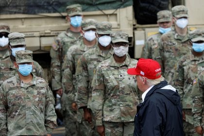 El presidente Donald Trump pasa junto a miembros de la Guardia Nacional que trabajan en tareas de emergencia provocadas por el huracán Laura.  REUTERS / Tom Brenner