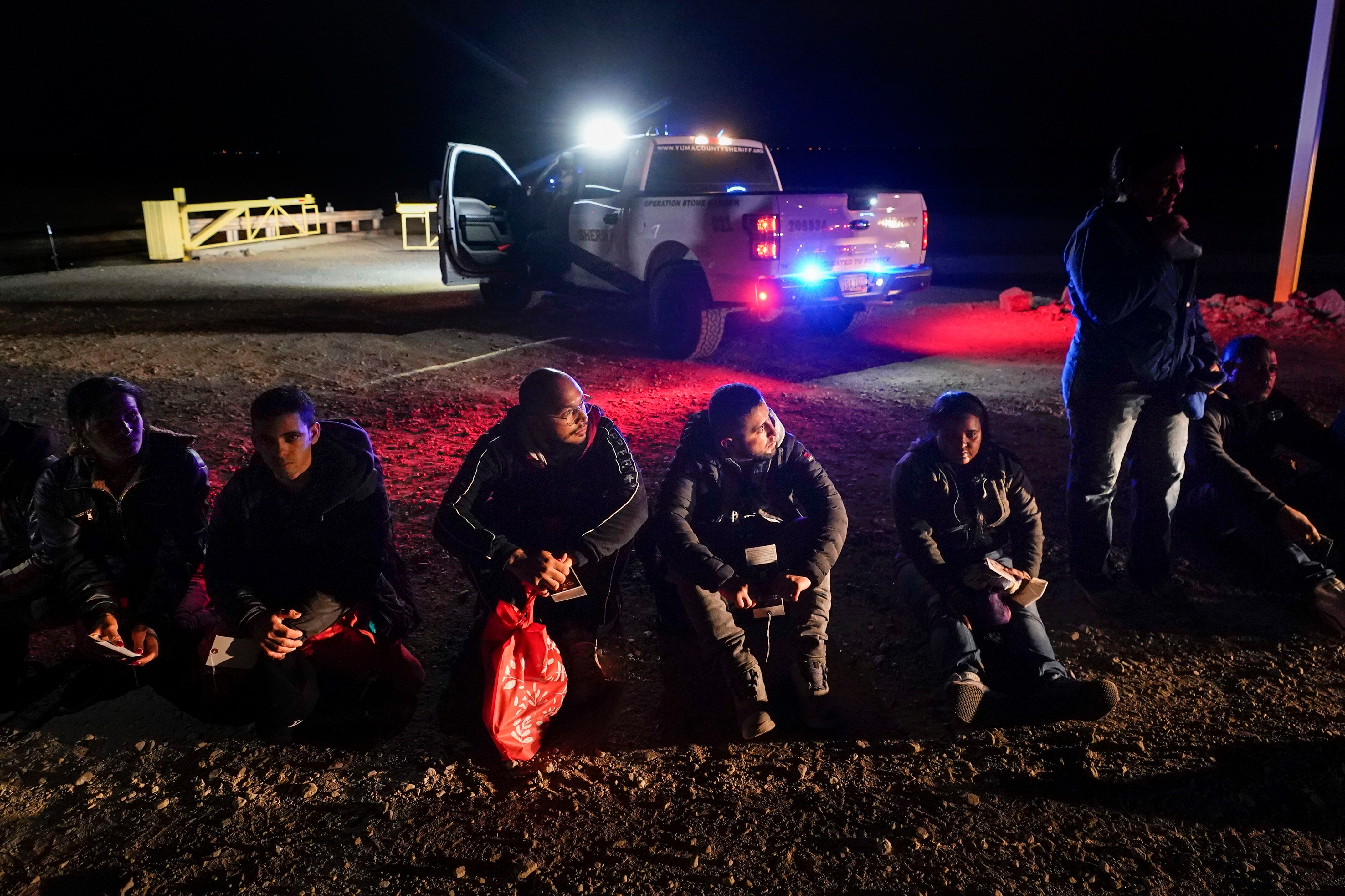 Migrantes esperan a ser procesados después de cruzar la frontera, cerca de Yuma, Arizona. (AP Foto/Gregory Bull, Archivo)