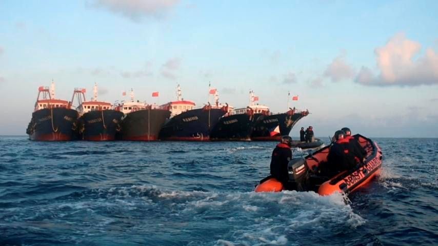 Personal de la Guardia Costera de Filipinas a bordo de un bote de goma mientras navegan cerca de embarcaciones chinas que se cree que están tripuladas por personal de la milicia marítima china en Whitsun Reef, Mar de China Meridional (Reuters)