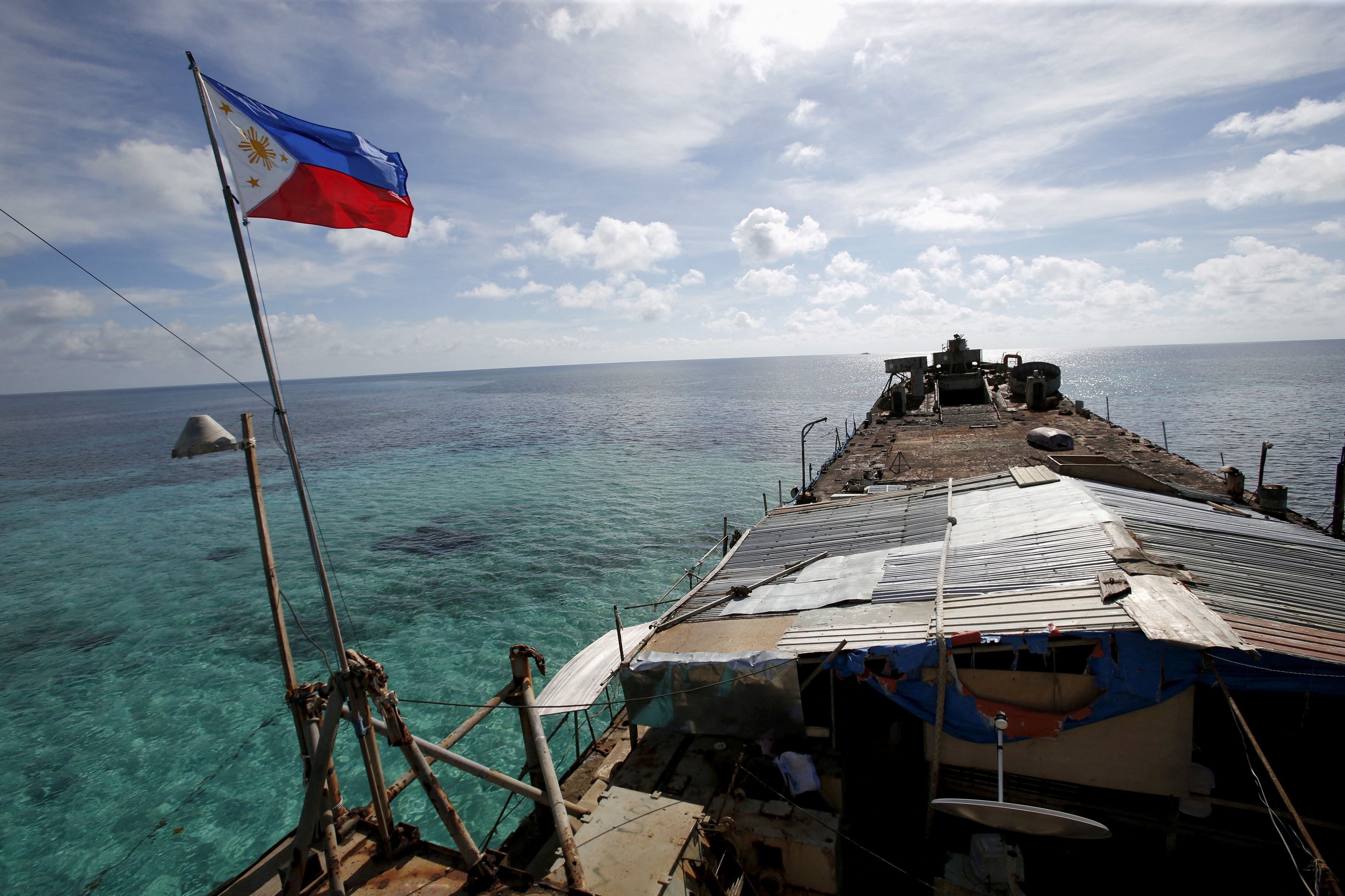 Una bandera filipina ondea desde el Sierra Madre, un destartalado buque de la Armada filipina encallado desde 1999 y convertido en destacamento militar filipino en el disputado atolón Second Thomas. (REUTERS/Erik De Castro/archivo)