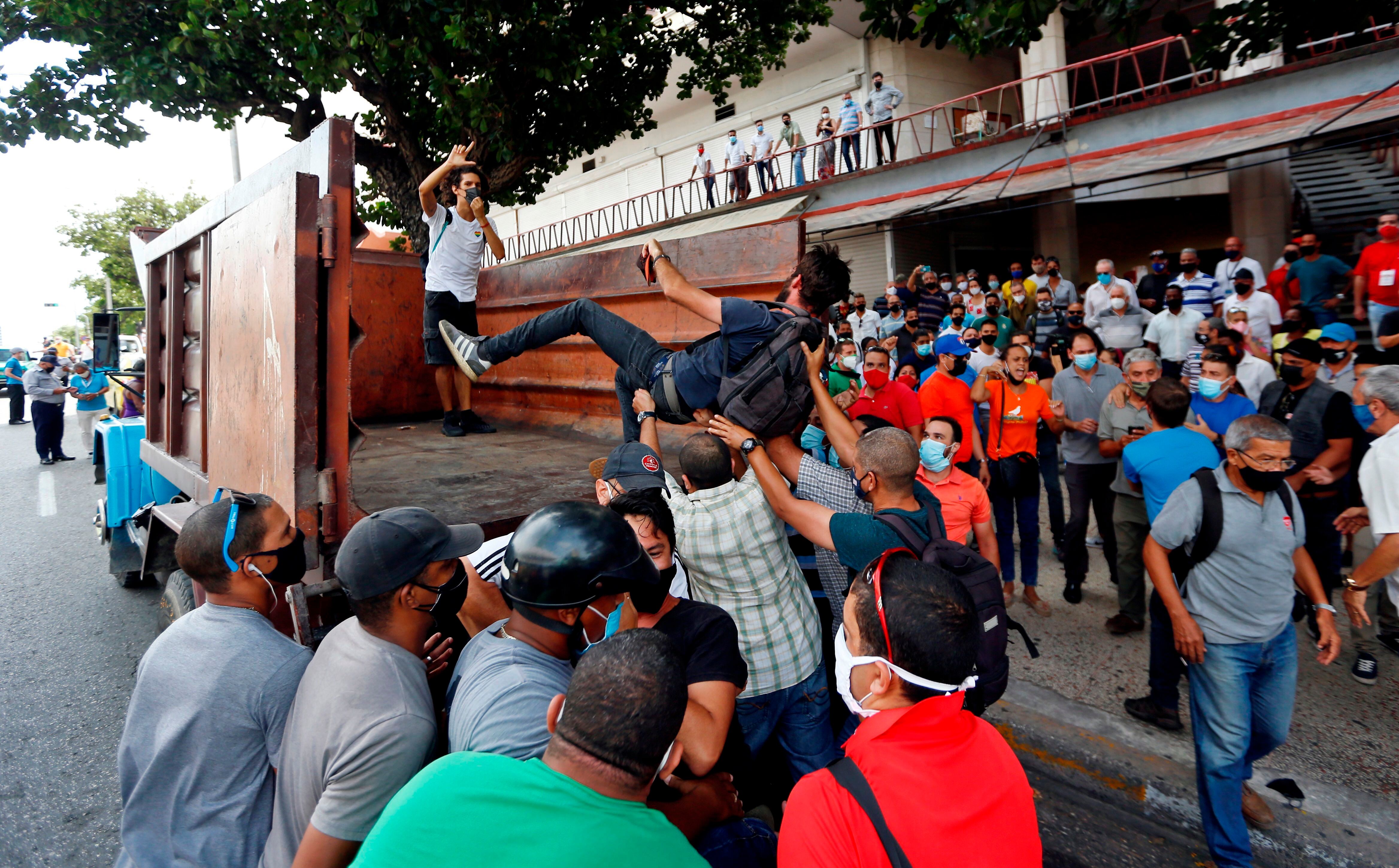 Manifestantes frente al Instituto de Radio y Televisión (ICRT) mientras son montados en un camión en una calle en La Habana (EFE/Ernesto Mastrascusa/Archivo)