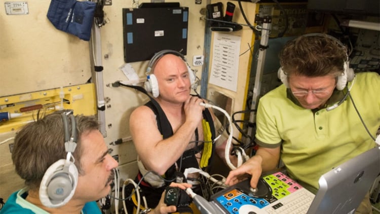 Scott Kelly (centro) utiliza un dispositivo Chibis de presión negativa en la parte inferior del cuerpo, mientras que los cosmonautas rusos ayudan a monitorear y medir médicamente sus fluidos corporales mientras están en órbita terrestre en 2015.