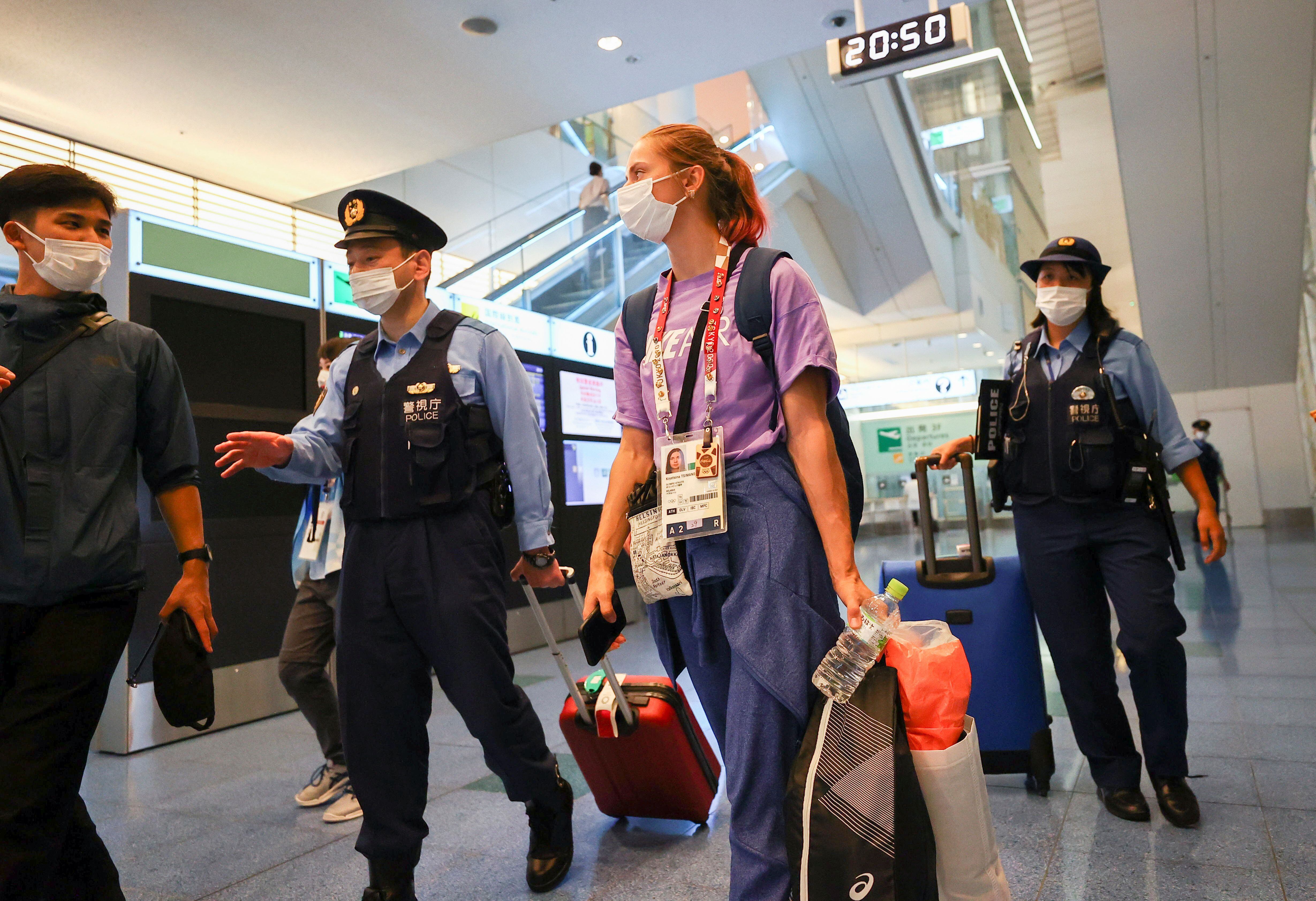 Tsimanouskaya escoltada por la policía en el aeropuerto (REUTERS/Issei Kato)