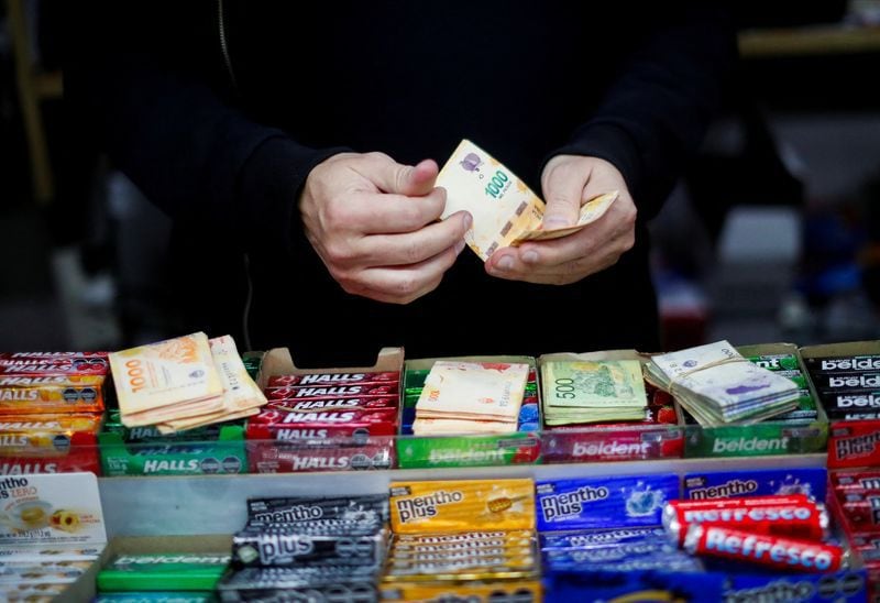 Un comerciante cuenta pesos argentinos en su comercio (REUTERS/Agustin Marcarian)